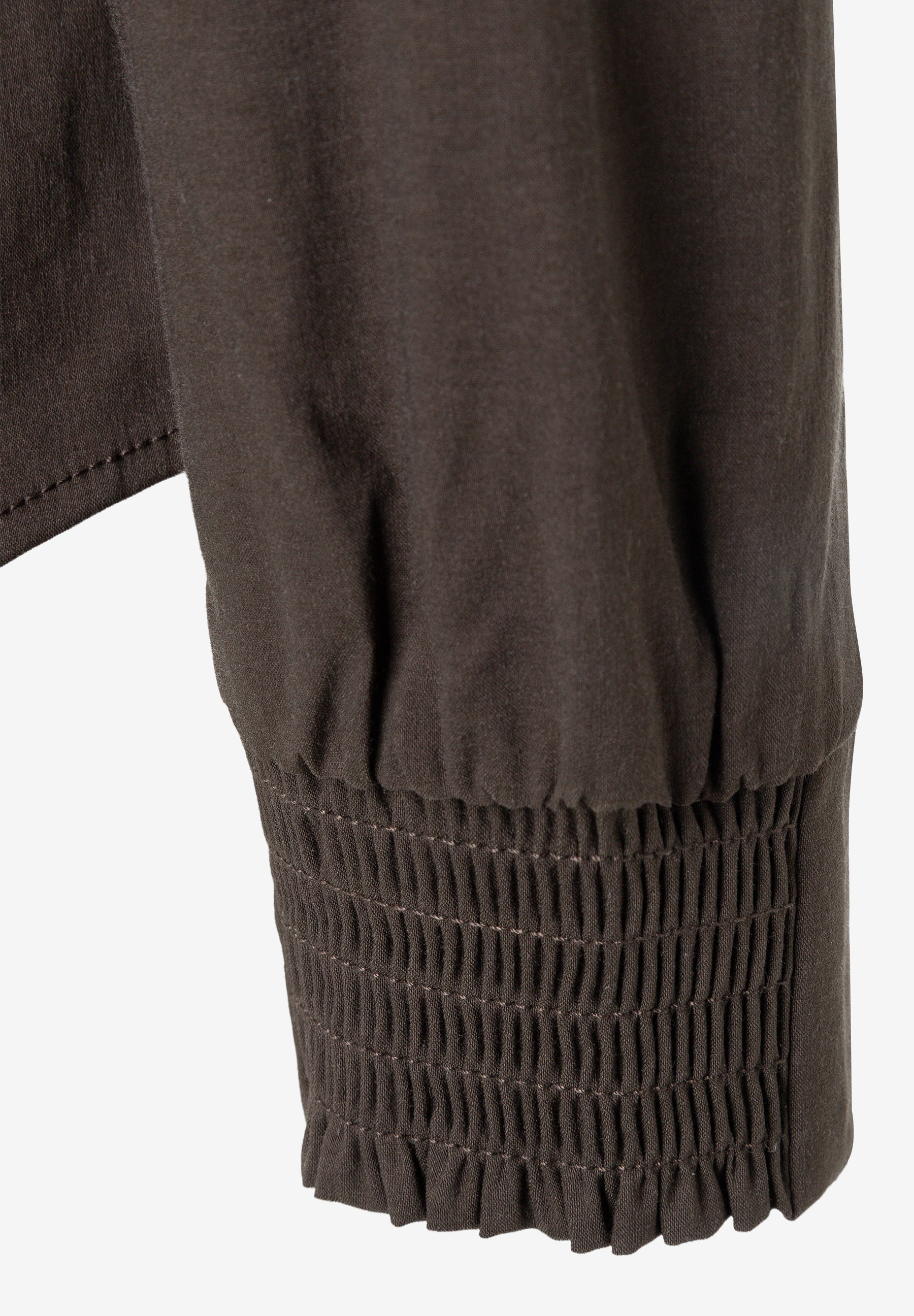 MORE & MORE Bluse: Detailaufnahme eines braunen Ärmels mit gerüschtem Bündchen am Handgelenk. MORE & MORE Bluse: Detailaufnahme eines braunen Ärmels mit gerüschtem Bündchen am Handgelenk.
