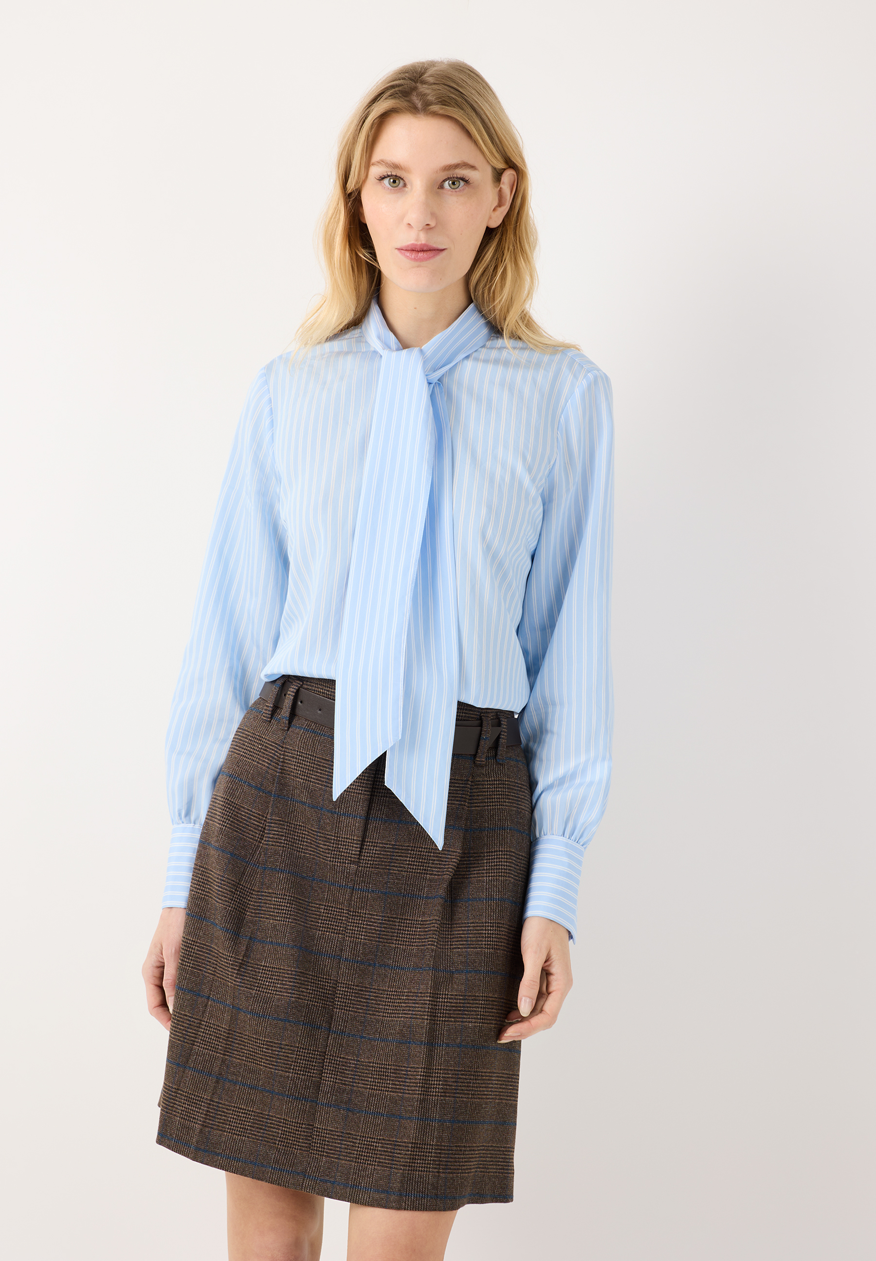 MORE & MORE Viskosemischungs-Bluse: Hellblau gestreiftes Oberteil mit Schluppe, kombiniert mit braunem Karorock. MORE & MORE Viskosemischungs-Bluse: Hellblau gestreiftes Oberteil mit Schluppe, kombiniert mit braunem Karorock.