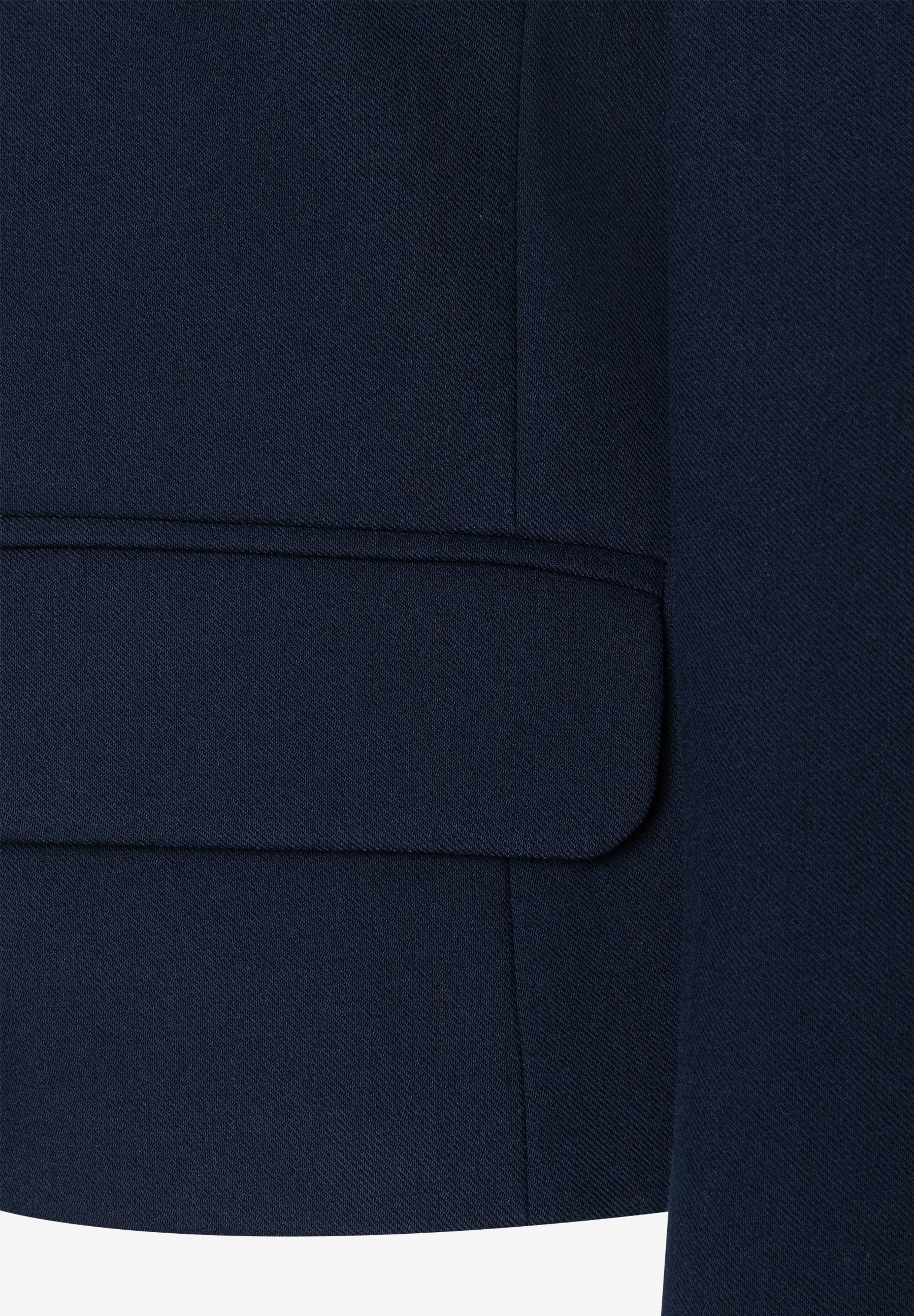 Detailansicht eines MORE & MORE Blazers, der eine aufgesetzte Tasche zeigt. Detailansicht eines MORE & MORE Blazers, der eine aufgesetzte Tasche zeigt.