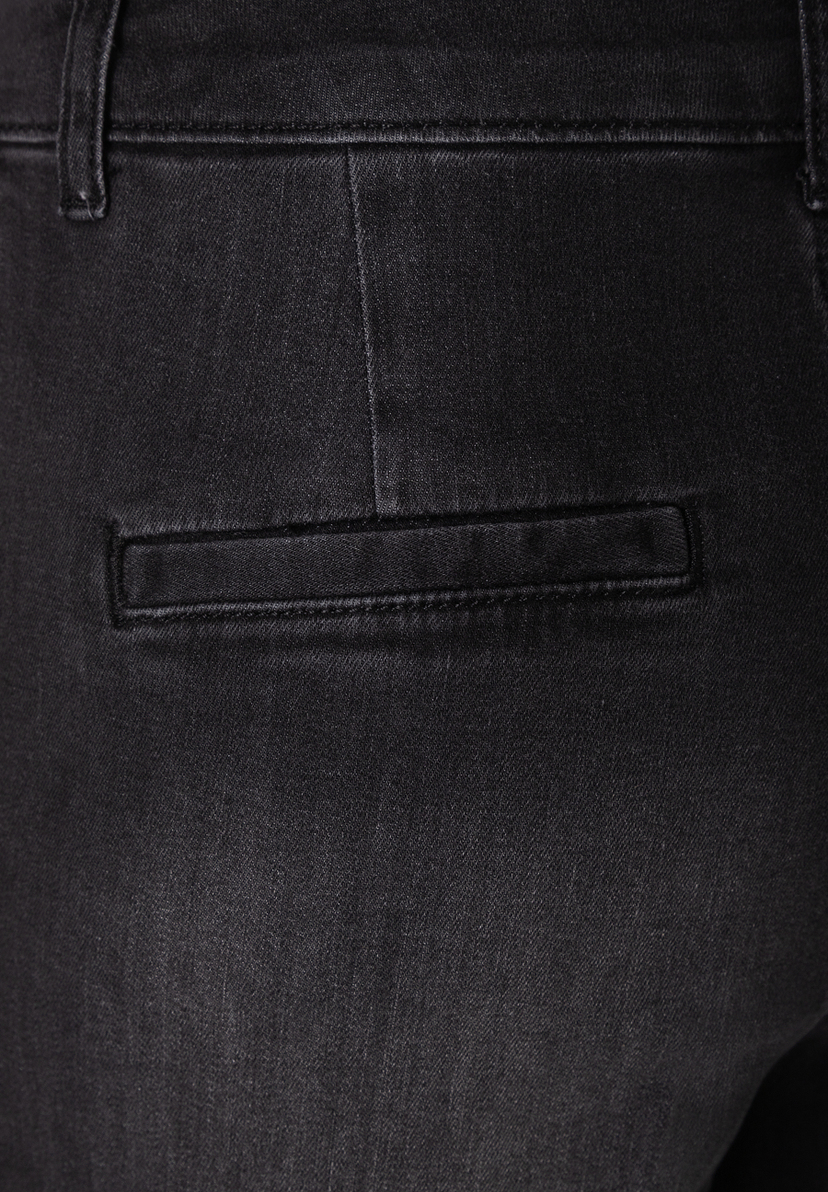 MORE & MORE Jeans: Nahaufnahme einer schwarzen Jeans mit einer angedeuteten Tasche hinten.