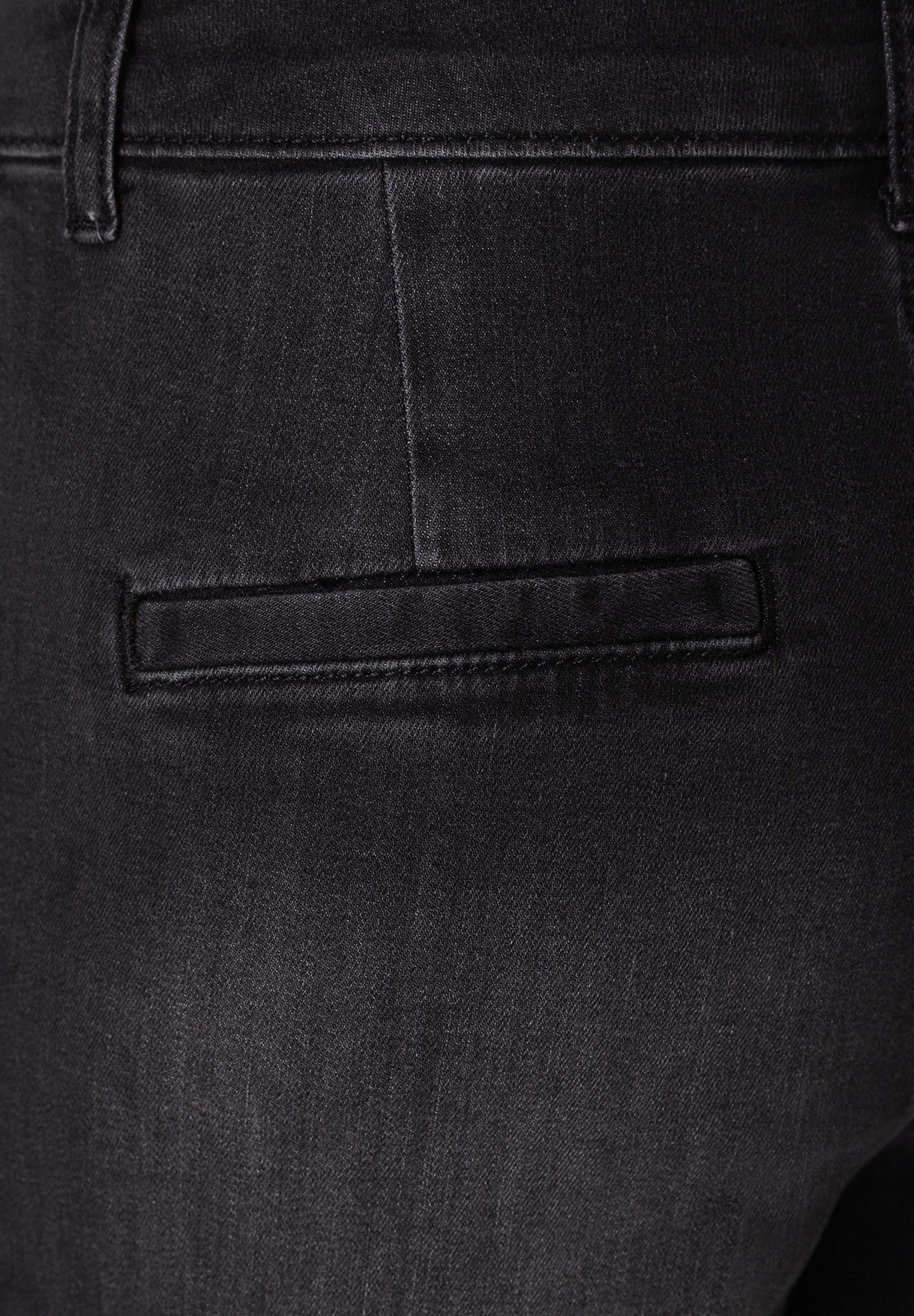 MORE & MORE Jeans: Nahaufnahme einer schwarzen Jeans mit einer angedeuteten Tasche hinten. MORE & MORE Jeans: Nahaufnahme einer schwarzen Jeans mit einer angedeuteten Tasche hinten.