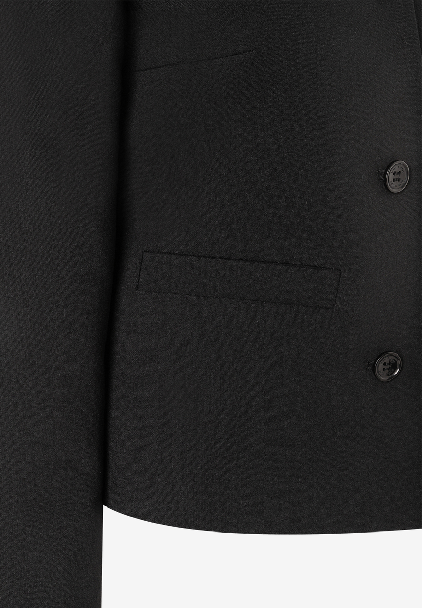 Nahaufnahme eines schwarzen MORE & MORE Blazers mit zwei Knöpfen und einer angedeuteten Tasche. Webware mit Tragekomfort. Nahaufnahme eines schwarzen MORE & MORE Blazers mit zwei Knöpfen und einer angedeuteten Tasche. Webware mit Tragekomfort.