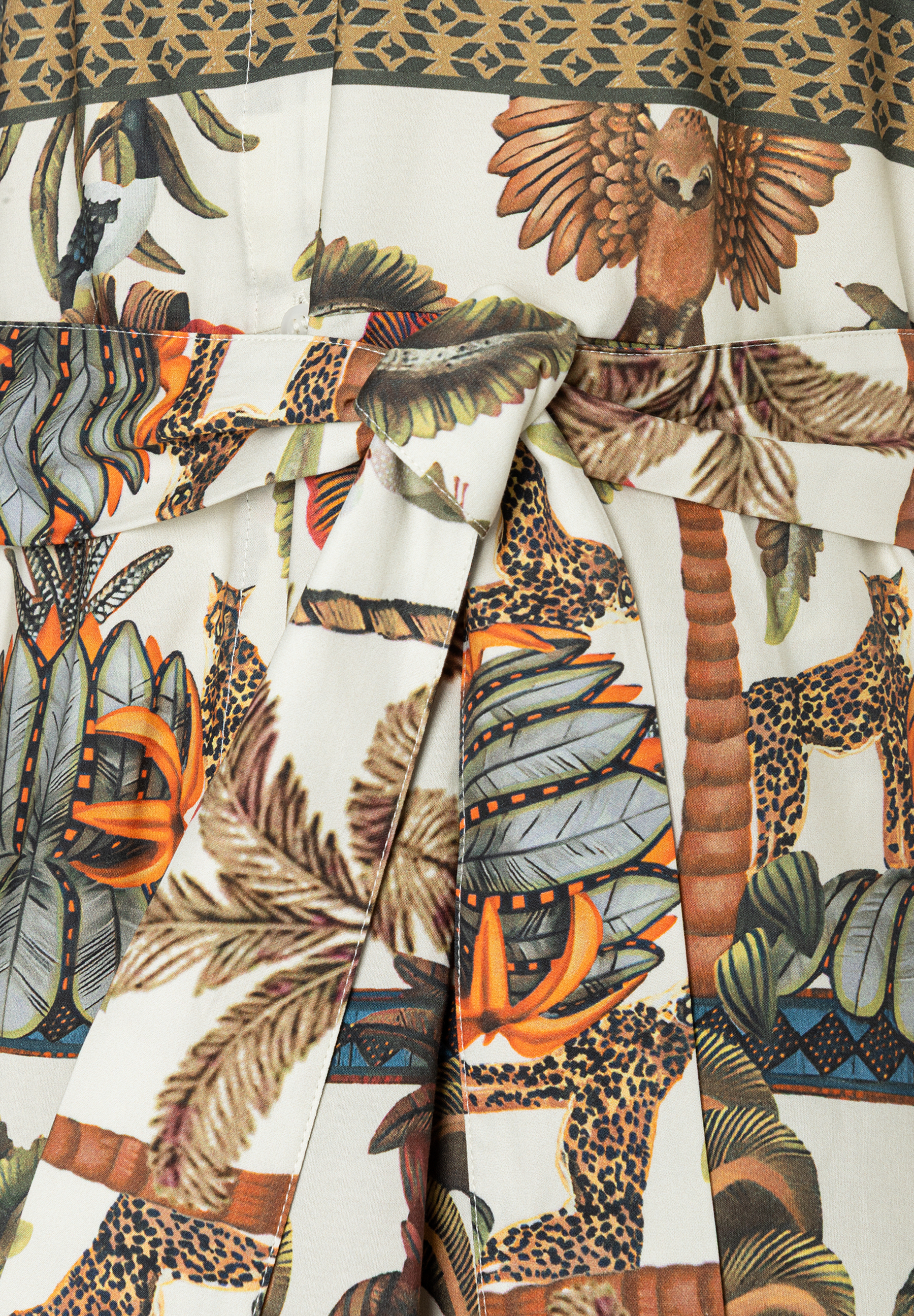 MORE & MORE Kleid: Nahaufnahme des Stoffes mit Dschungel-Print aus Leoparden, Palmen und Vögeln. Ein Stoffband ist gebunden. MORE & MORE Kleid: Nahaufnahme des Stoffes mit Dschungel-Print aus Leoparden, Palmen und Vögeln. Ein Stoffband ist gebunden.
