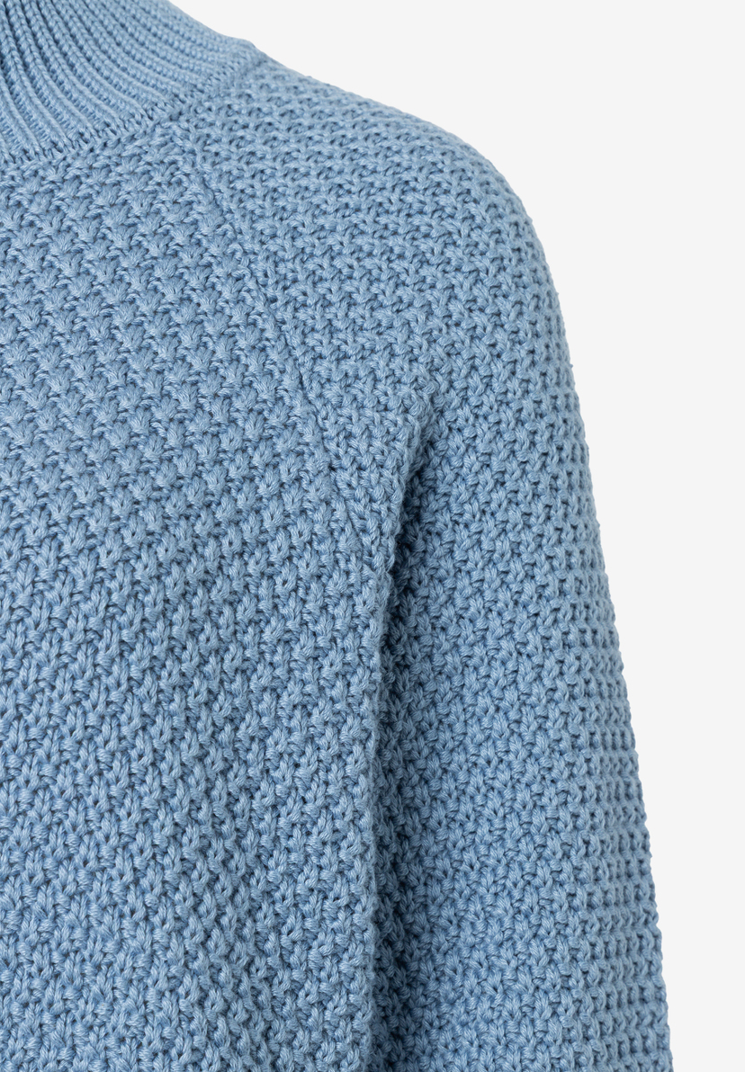 MORE & MORE Pullover: Nahaufnahme eines himmelblauen Strickpullovers mit grobem Strickmuster, geripptem Kragen und Ärmeln. MORE & MORE Pullover: Nahaufnahme eines himmelblauen Strickpullovers mit grobem Strickmuster, geripptem Kragen und Ärmeln.