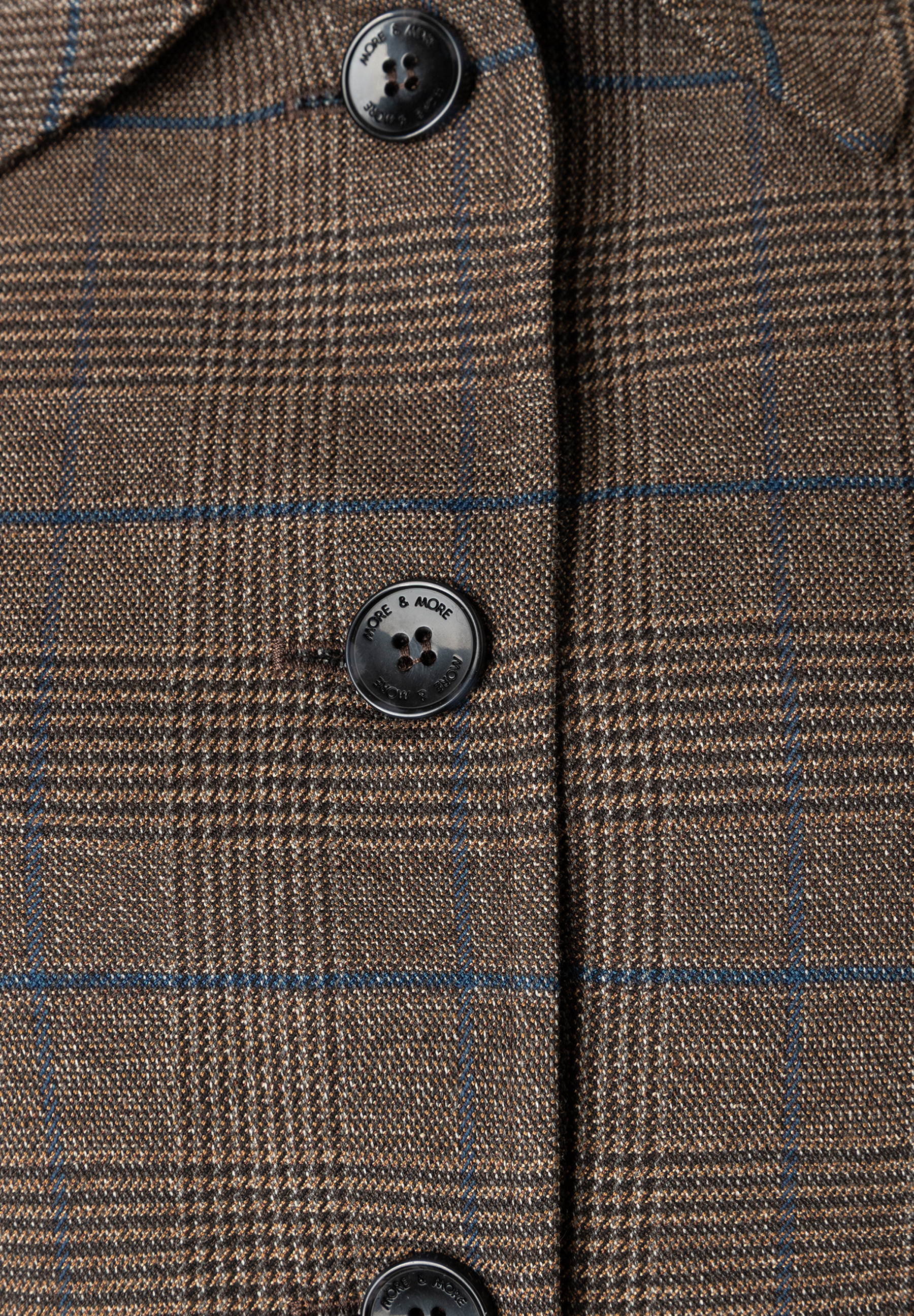 MORE & MORE Blazer: Detailansicht des braun-blau karierten Stoffs mit drei schwarzen Knöpfen, die jeweils "MORE & MORE" prägen.