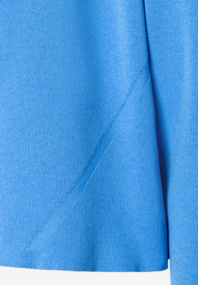 Nahaufnahme eines MORE & MORE Strickpullovers in hellem Blau mit diagonalem Detail. Nahaufnahme eines MORE & MORE Strickpullovers in hellem Blau mit diagonalem Detail.