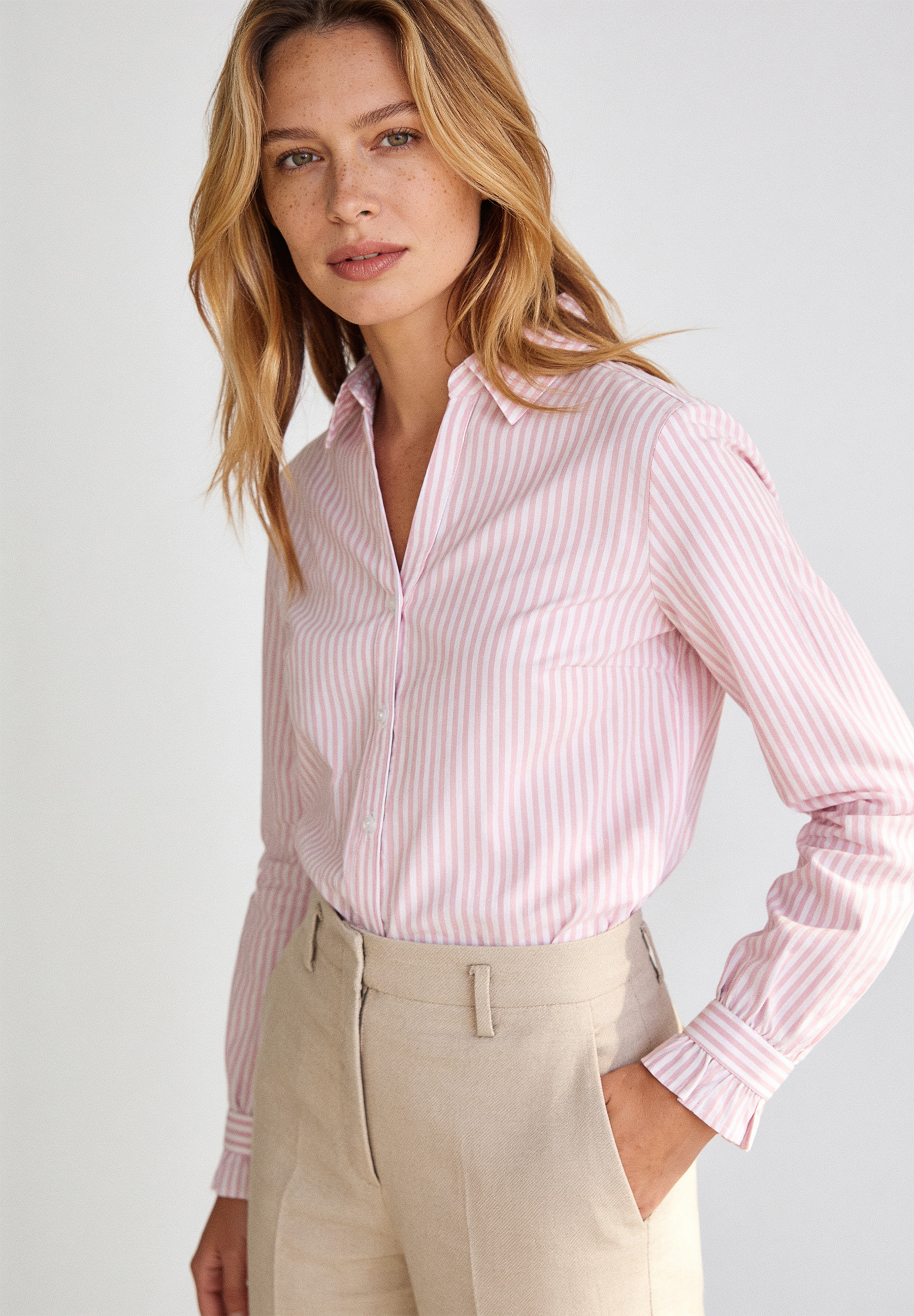 AI generated - MORE & MORE Popeline-Bluse in Rosa/Weiß gestreift. Modell trägt eine hautfreundliche und elastische Bluse und helle Hose.