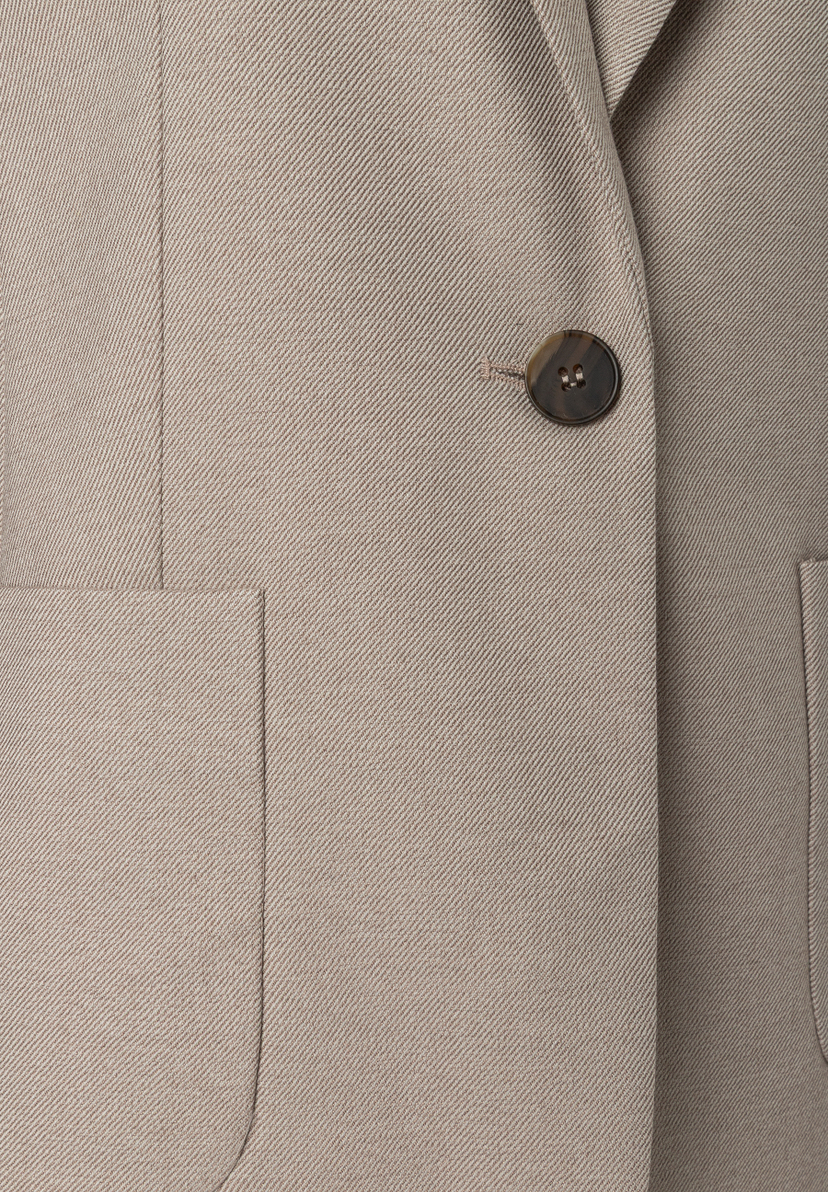MORE & MORE Blazer: Detailansicht des beige-grauen Stoffs mit diagonalem Webmuster. Ein runder Knopf in Hornoptik schmückt die rechte Brustseite des Blazers. Darunter ist eine aufgesetzte Tasche mit gerundeten Ecken zu sehen. MORE & MORE Blazer: Detailansicht des beige-grauen Stoffs mit diagonalem Webmuster. Ein runder Knopf in Hornoptik schmückt die rechte Brustseite des Blazers. Darunter ist eine aufgesetzte Tasche mit gerundeten Ecken zu sehen.