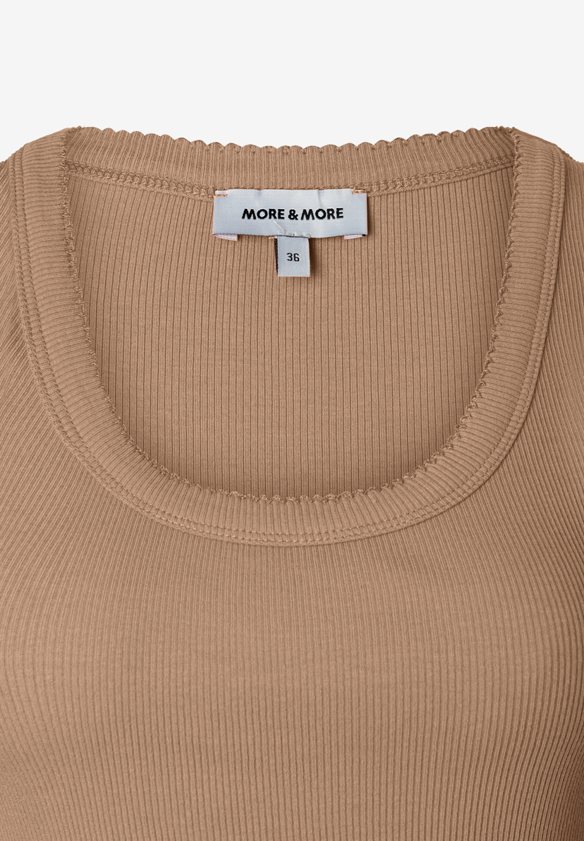 Nahaufnahme eines gerippten MORE & MORE Tops in Beige mit Markenetikett und Größenangabe. Nahaufnahme eines gerippten MORE & MORE Tops in Beige mit Markenetikett und Größenangabe.