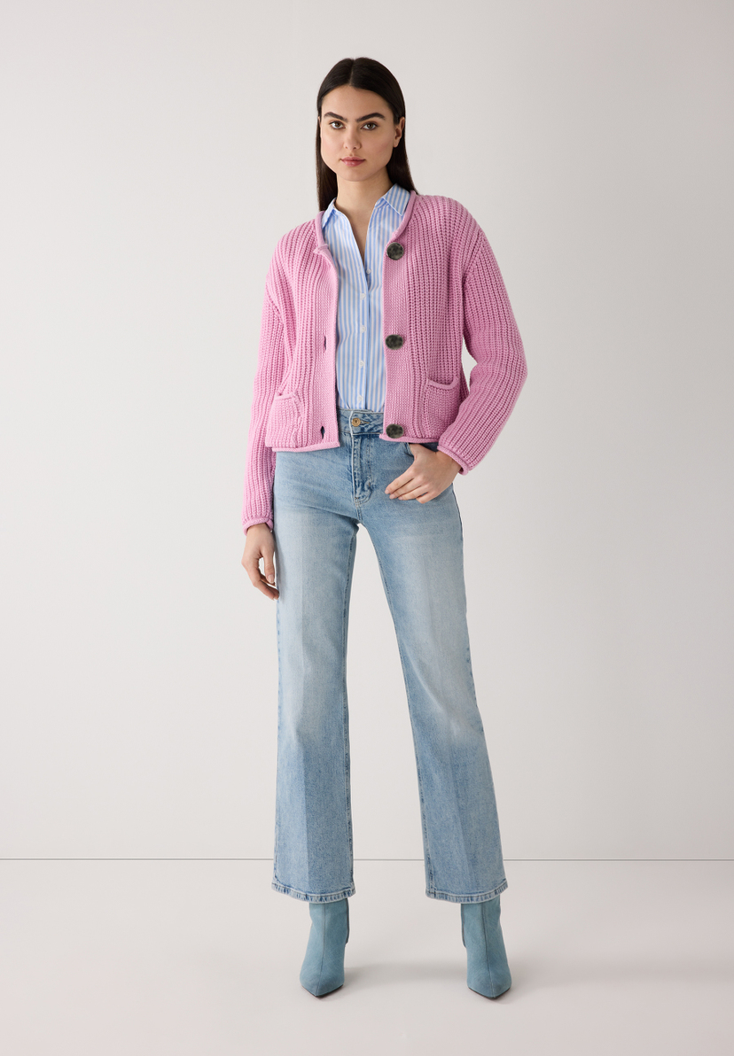 Eine Frau in MORE & MORE Strickware. Sie trägt eine blaue Bluse, Jeans und hellblaue Stiefeletten. Eine Frau in MORE & MORE Strickware. Sie trägt eine blaue Bluse, Jeans und hellblaue Stiefeletten.