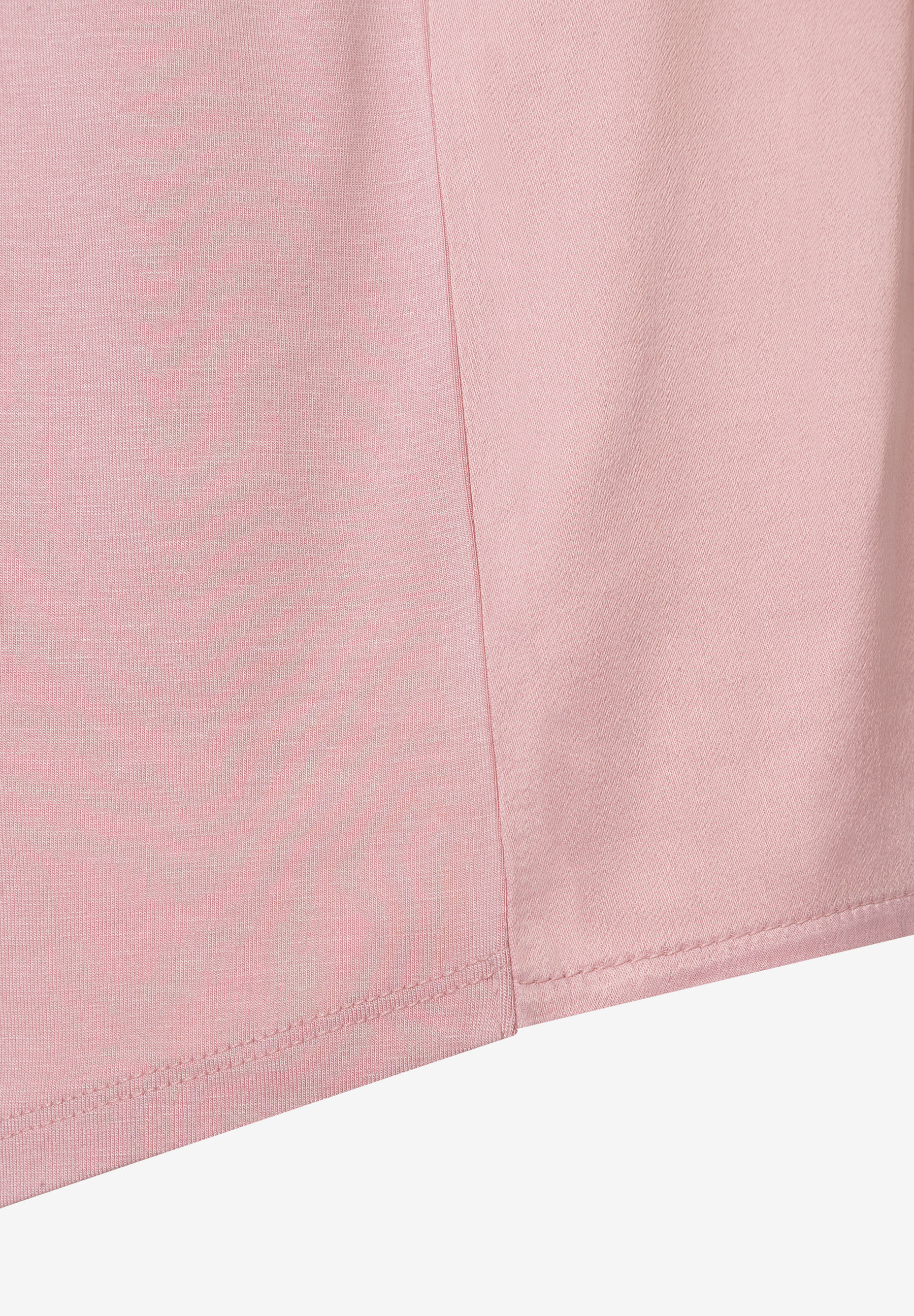 Nahaufnahme eines MORE & MORE Oberteils aus rosa Jersey und Satin mit glänzender Optik. Nahaufnahme eines MORE & MORE Oberteils aus rosa Jersey und Satin mit glänzender Optik.