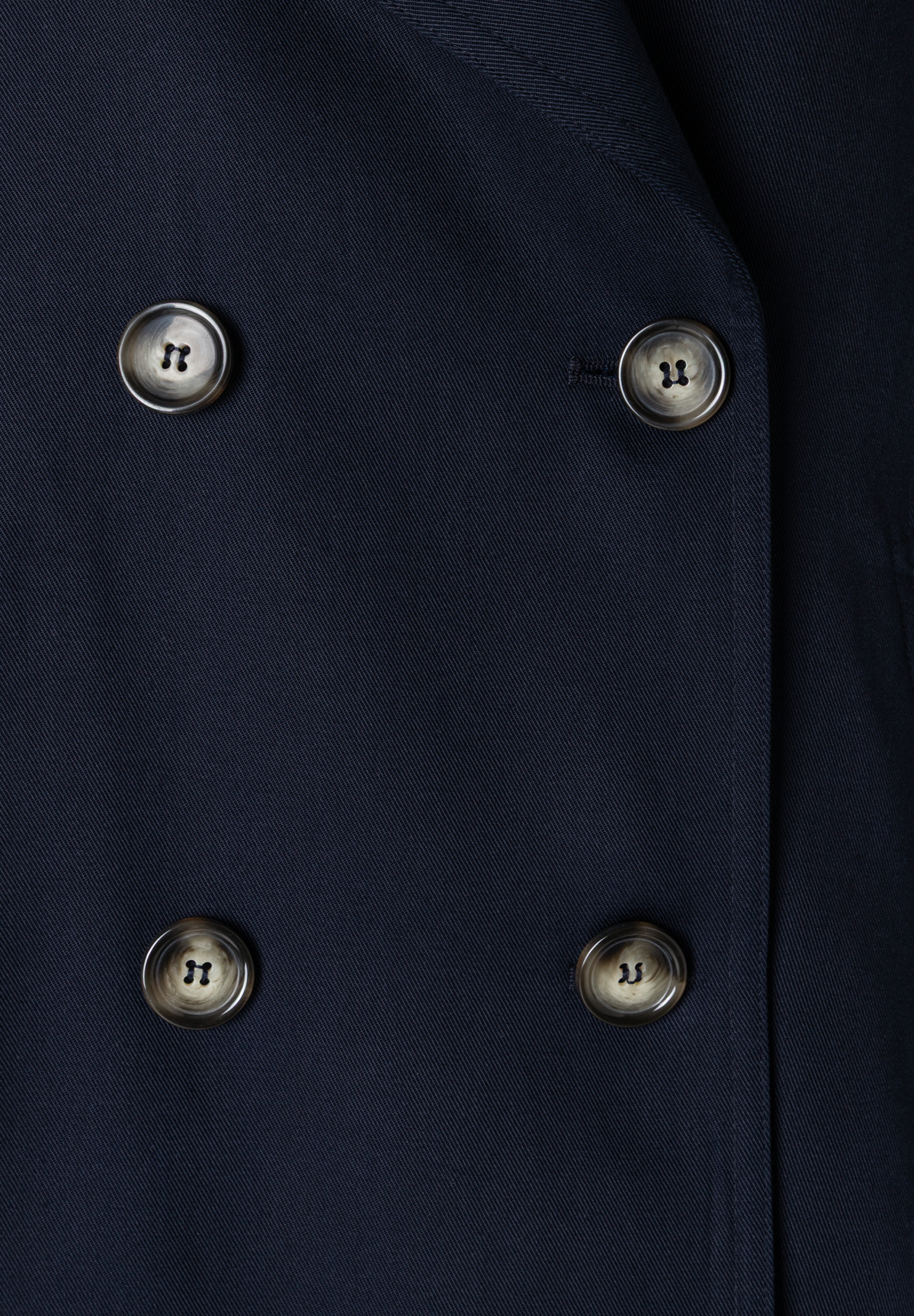 Detailansicht eines MORE & MORE Oberteils aus Twill mit vier Knöpfen. Detailansicht eines MORE & MORE Oberteils aus Twill mit vier Knöpfen.