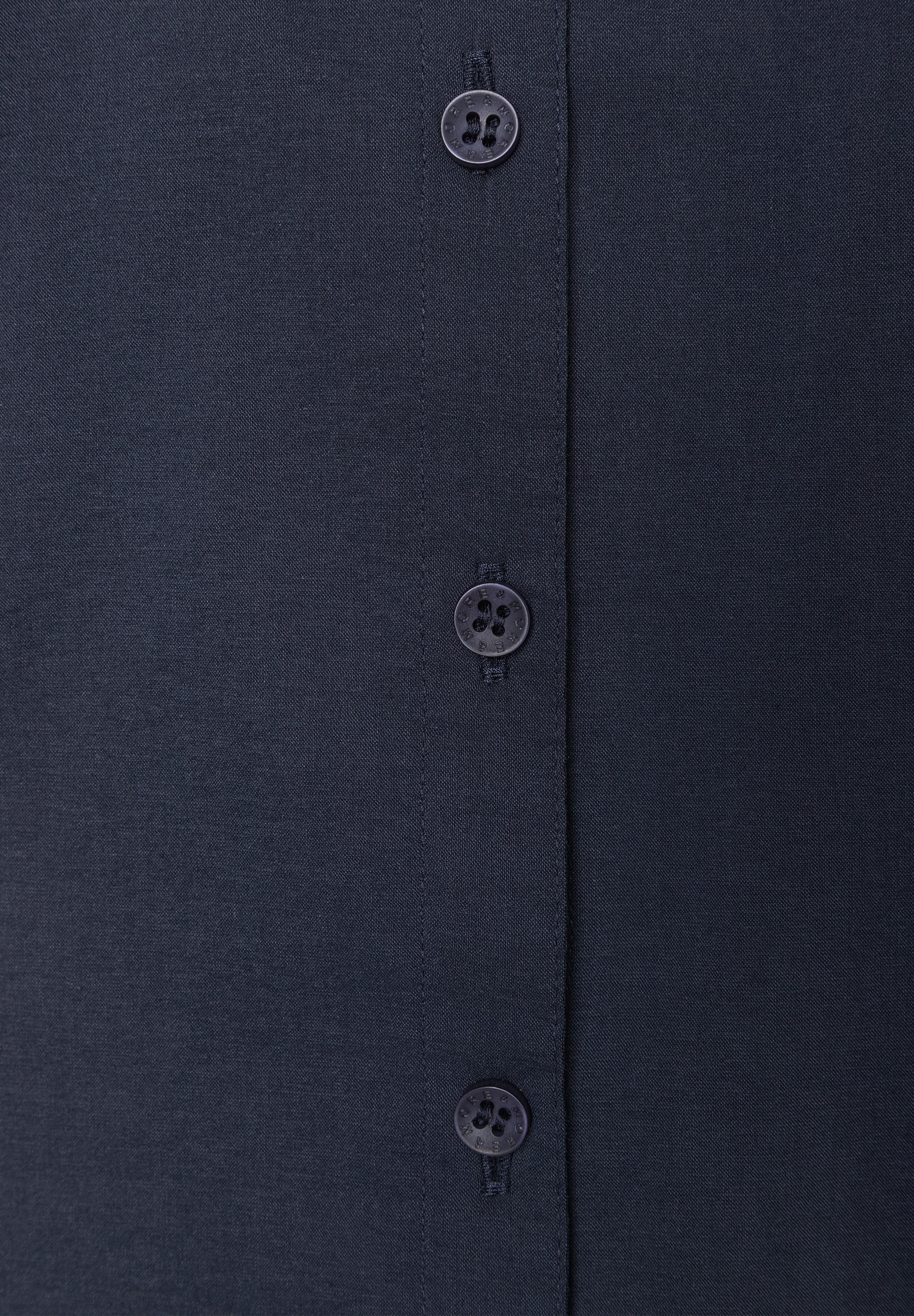 Nahaufnahme der MORE & MORE Bluse aus Popeline mit Knöpfen, die angenehmen Tragekomfort und Elastizität versprechen. Nahaufnahme der MORE & MORE Bluse aus Popeline mit Knöpfen, die angenehmen Tragekomfort und Elastizität versprechen.