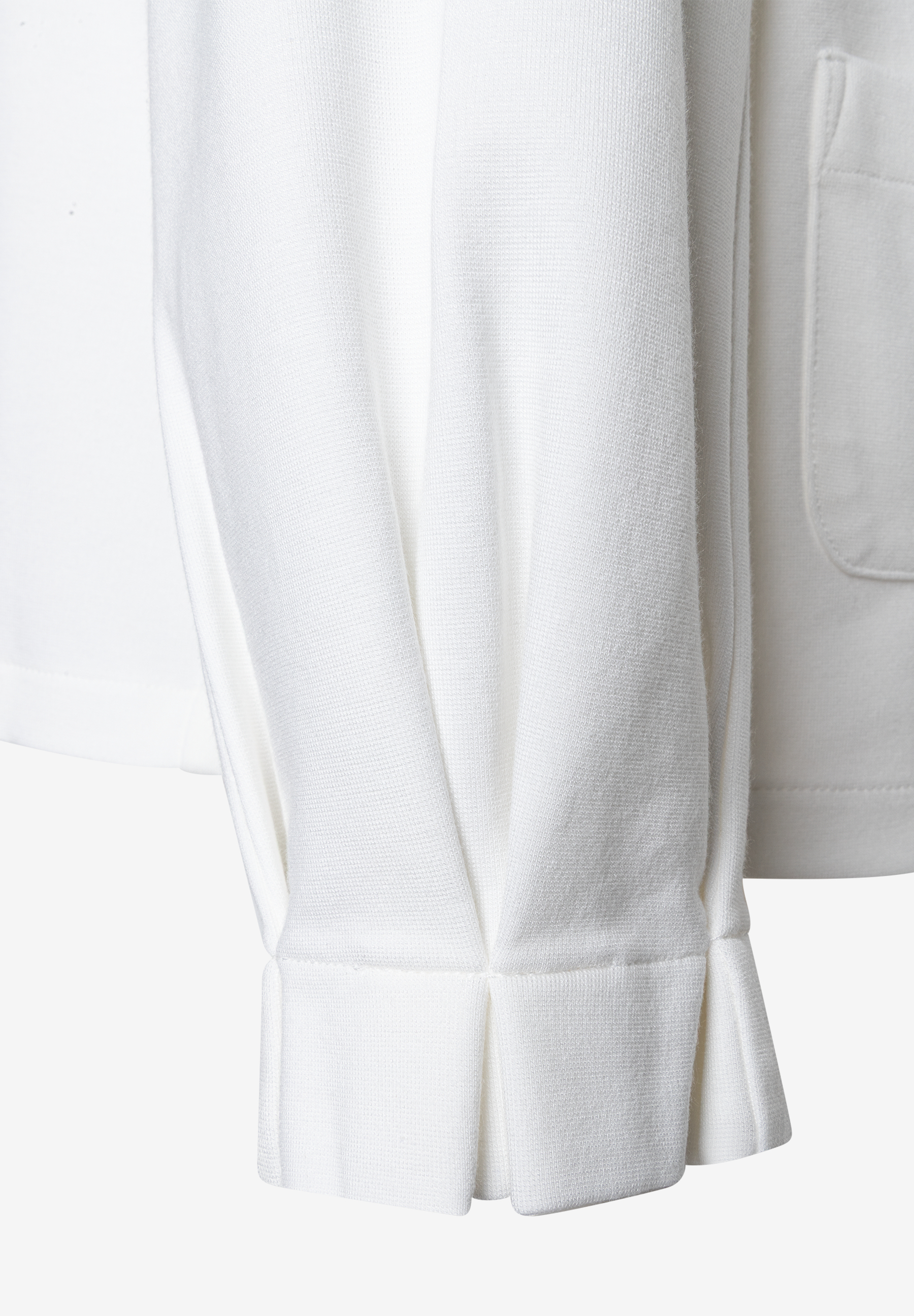 Nahaufnahme eines weißen MORE & MORE T-Shirts/Tops, Ärmeldetail. Nahaufnahme eines weißen MORE & MORE T-Shirts/Tops, Ärmeldetail.