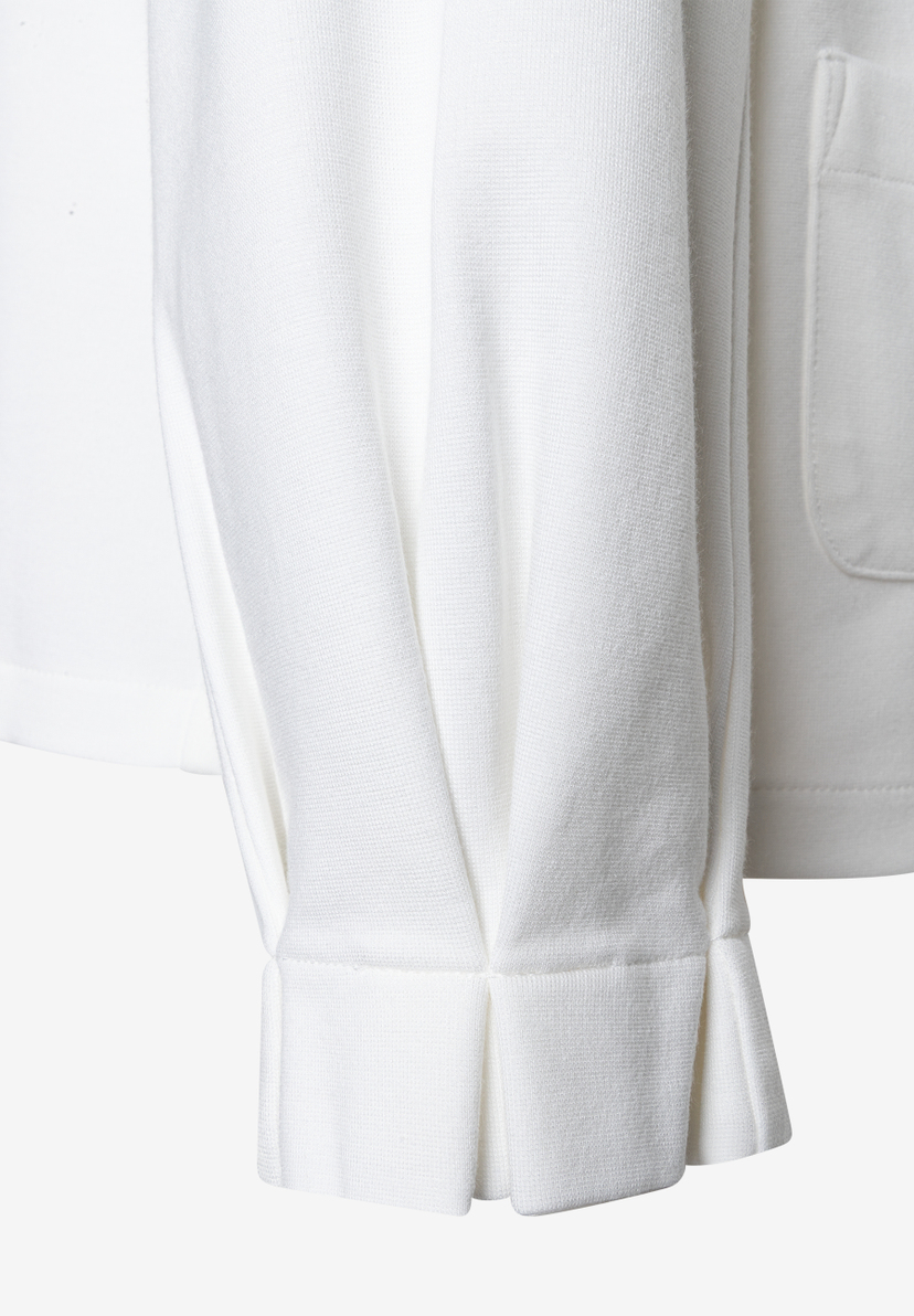 Nahaufnahme eines weißen MORE & MORE T-Shirts/Tops, Ärmeldetail. Nahaufnahme eines weißen MORE & MORE T-Shirts/Tops, Ärmeldetail.