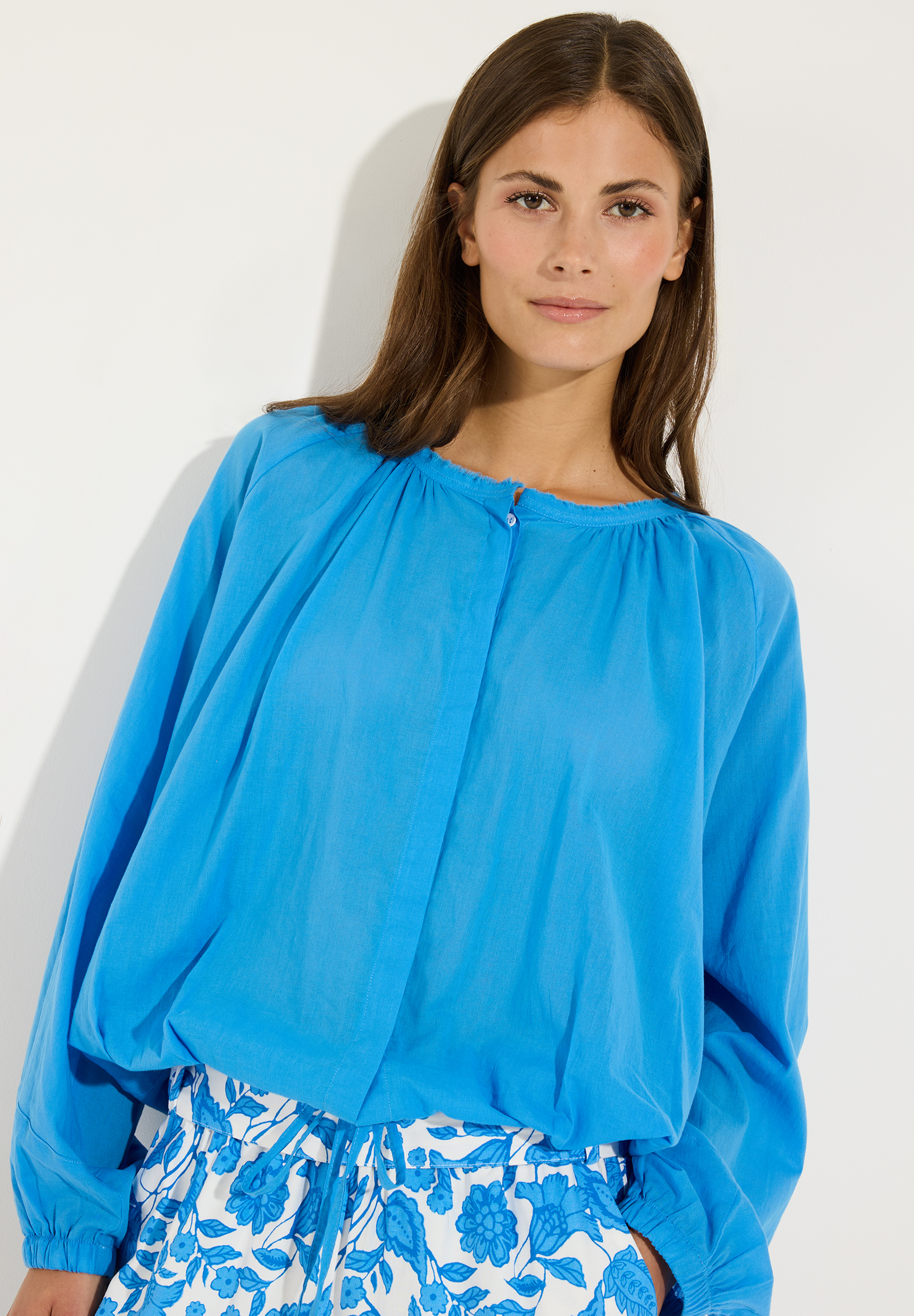 MORE & MORE Bluse aus leichter Baumwollwebware in leuchtendem Blau, kombiniert mit floral gemusterten Shorts in Weiß-Blau. MORE & MORE Bluse aus leichter Baumwollwebware in leuchtendem Blau, kombiniert mit floral gemusterten Shorts in Weiß-Blau.