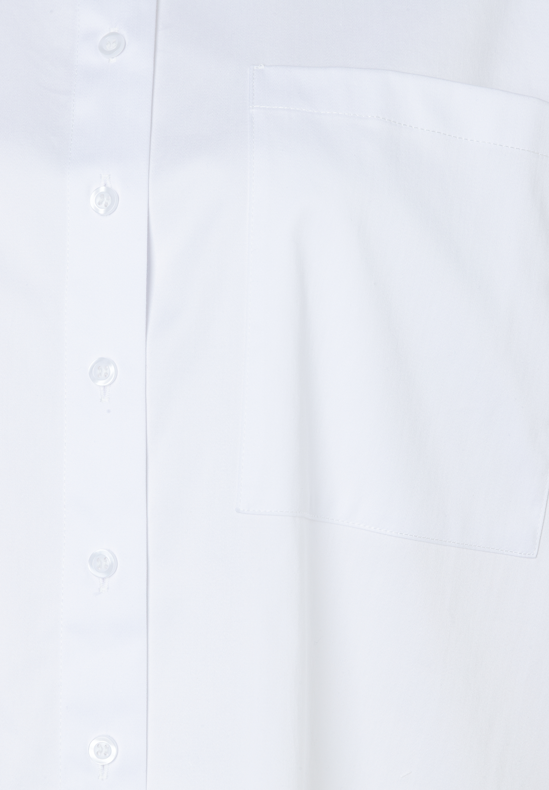 Detailansicht einer weißen MORE & MORE Bluse mit Knöpfen und einer Brusttasche. Detailansicht einer weißen MORE & MORE Bluse mit Knöpfen und einer Brusttasche.