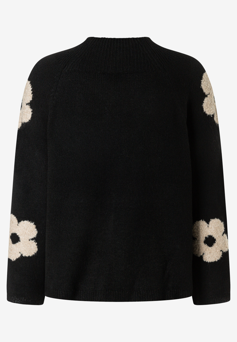 MORE & MORE Pullover mit beigefarbenen Blüten: Ein schwarzer, gestrickter Pullover mit Rollkragen und langen Ärmeln. Drei cremefarbene Blüten sind seitlich angeordnet, eine davon auf der Vorderseite und zwei auf dem linken Ärmel.