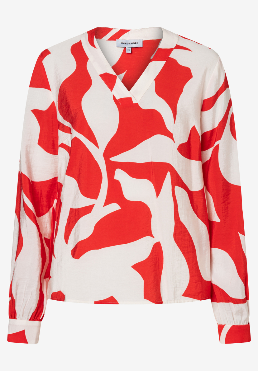 Eine rot-weiß gemusterte MORE & MORE Bluse mit V-Ausschnitt und langen Ärmeln. Eine rot-weiß gemusterte MORE & MORE Bluse mit V-Ausschnitt und langen Ärmeln.