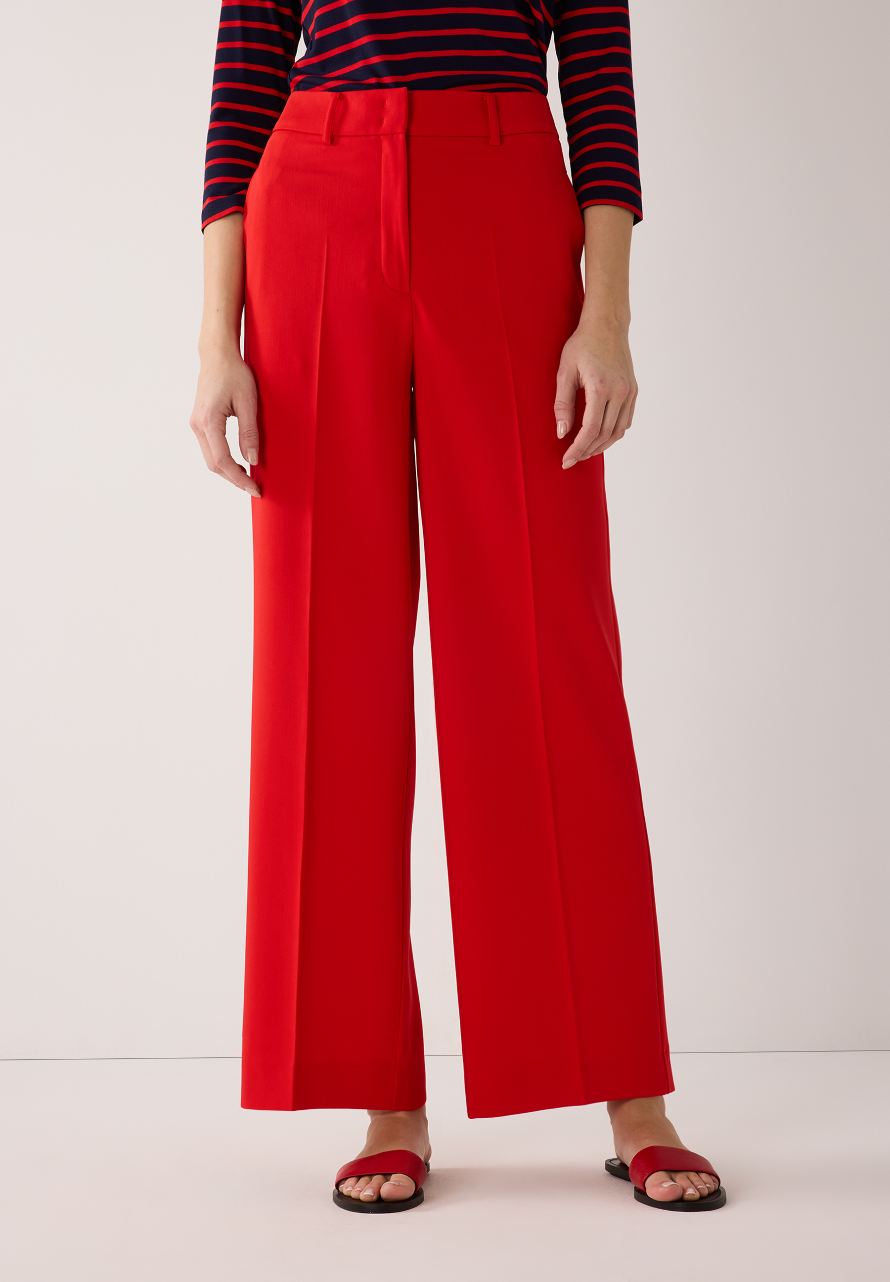 Eine Person mit roter MORE & MORE Hose. Weite, fließende Webware mit hohem Tragekomfort.