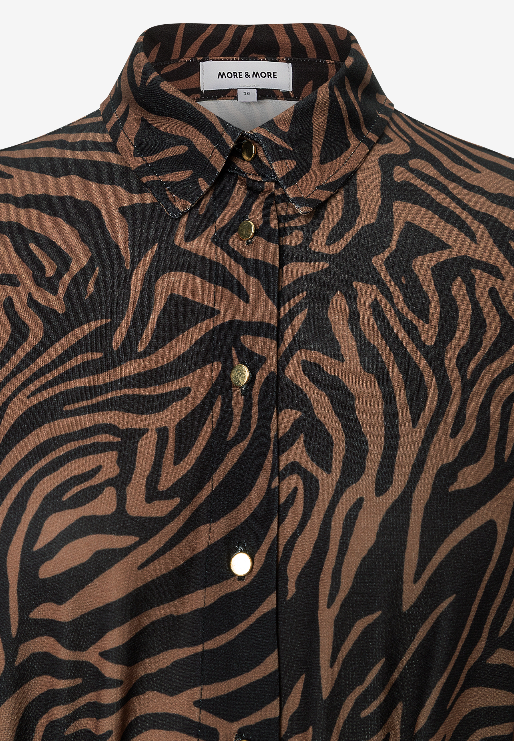 Ein MORE & MORE-Oberteil mit Jersey-Material und einem braun-schwarzen Zebramuster mit Knöpfen. Ein MORE & MORE-Oberteil mit Jersey-Material und einem braun-schwarzen Zebramuster mit Knöpfen.