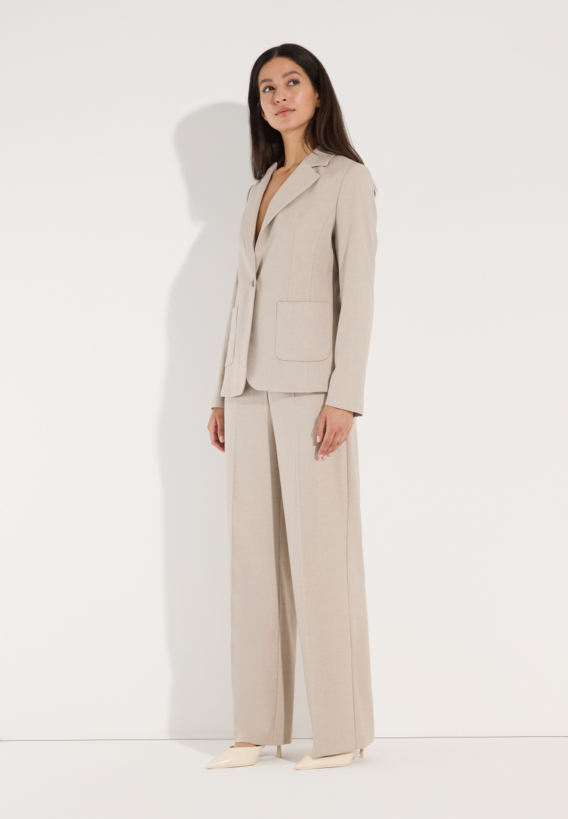 MORE & MORE beiger Webware-Blazer auf einem Model in voller Länge mit passenden Hosen und cremefarbenen Stilettos. MORE & MORE beiger Webware-Blazer auf einem Model in voller Länge mit passenden Hosen und cremefarbenen Stilettos.