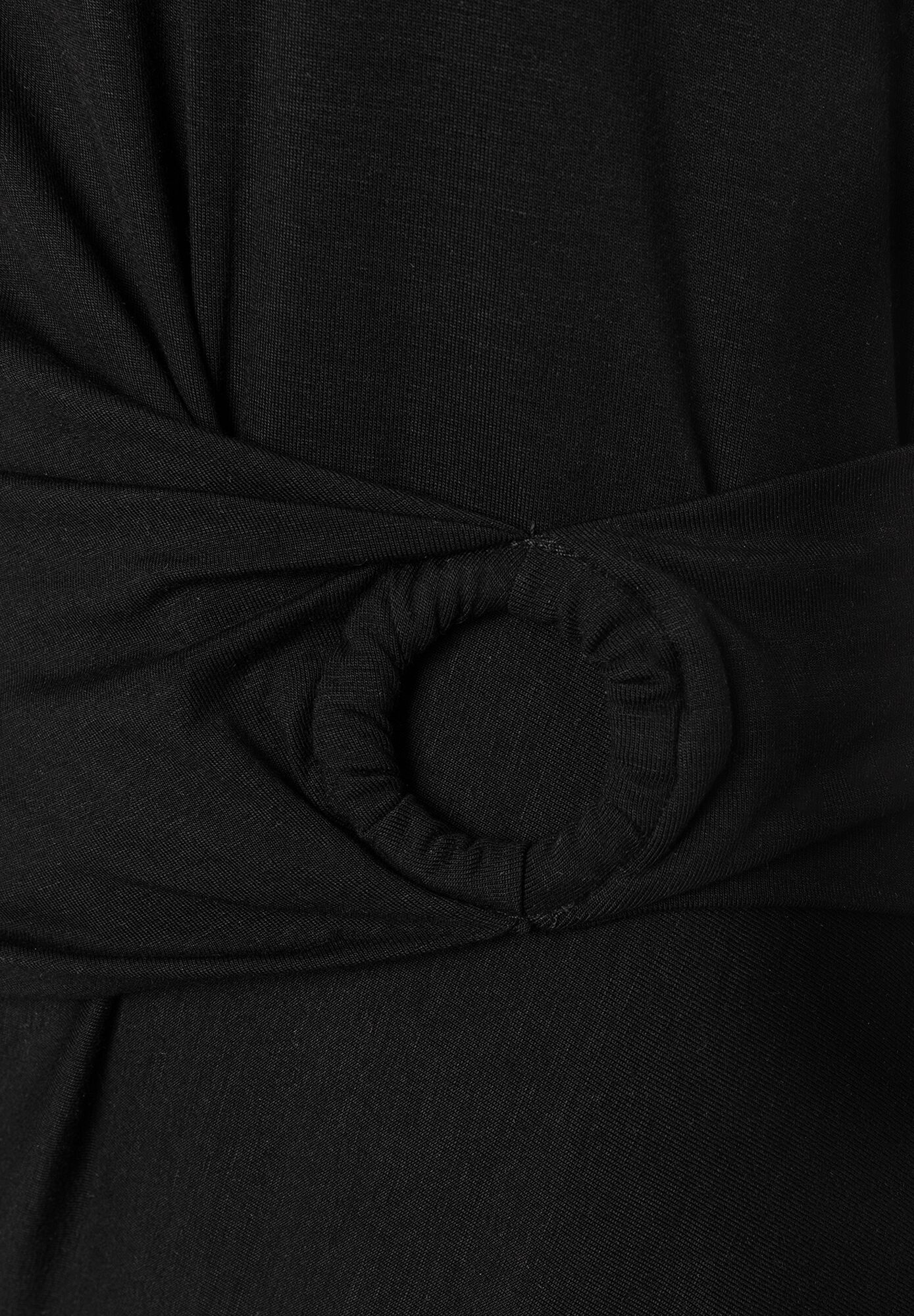 Nahaufnahme von schwarzem MORE & MORE Oberteil mit Jersey-Material und dekorativer Schnalle. Nahaufnahme von schwarzem MORE & MORE Oberteil mit Jersey-Material und dekorativer Schnalle.
