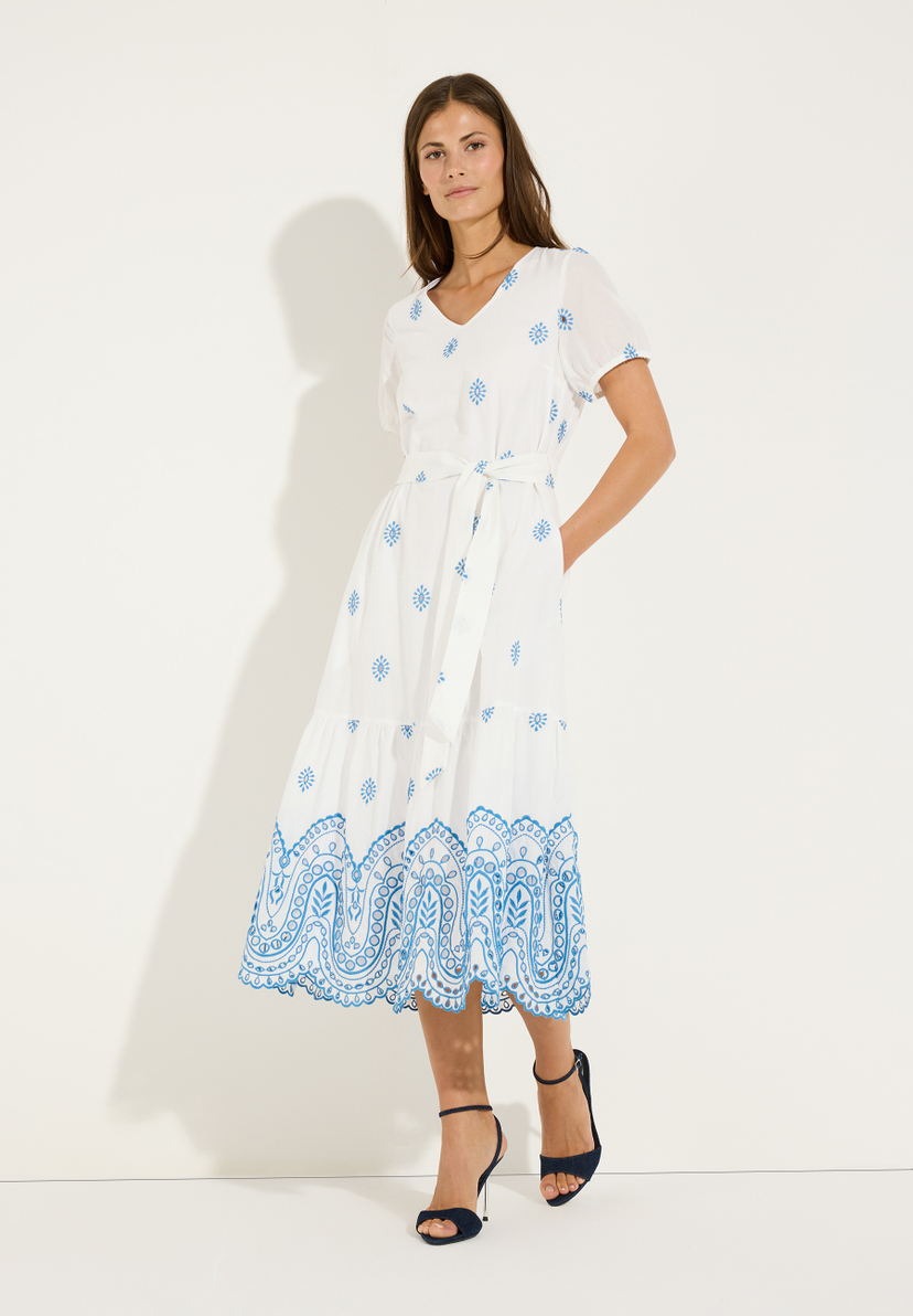 MORE & MORE Oberteil: Weißes Kleid mit blauen Blumenstickereien und Schnürung, kombiniert mit dunklen Absätzen. MORE & MORE Oberteil: Weißes Kleid mit blauen Blumenstickereien und Schnürung, kombiniert mit dunklen Absätzen.
