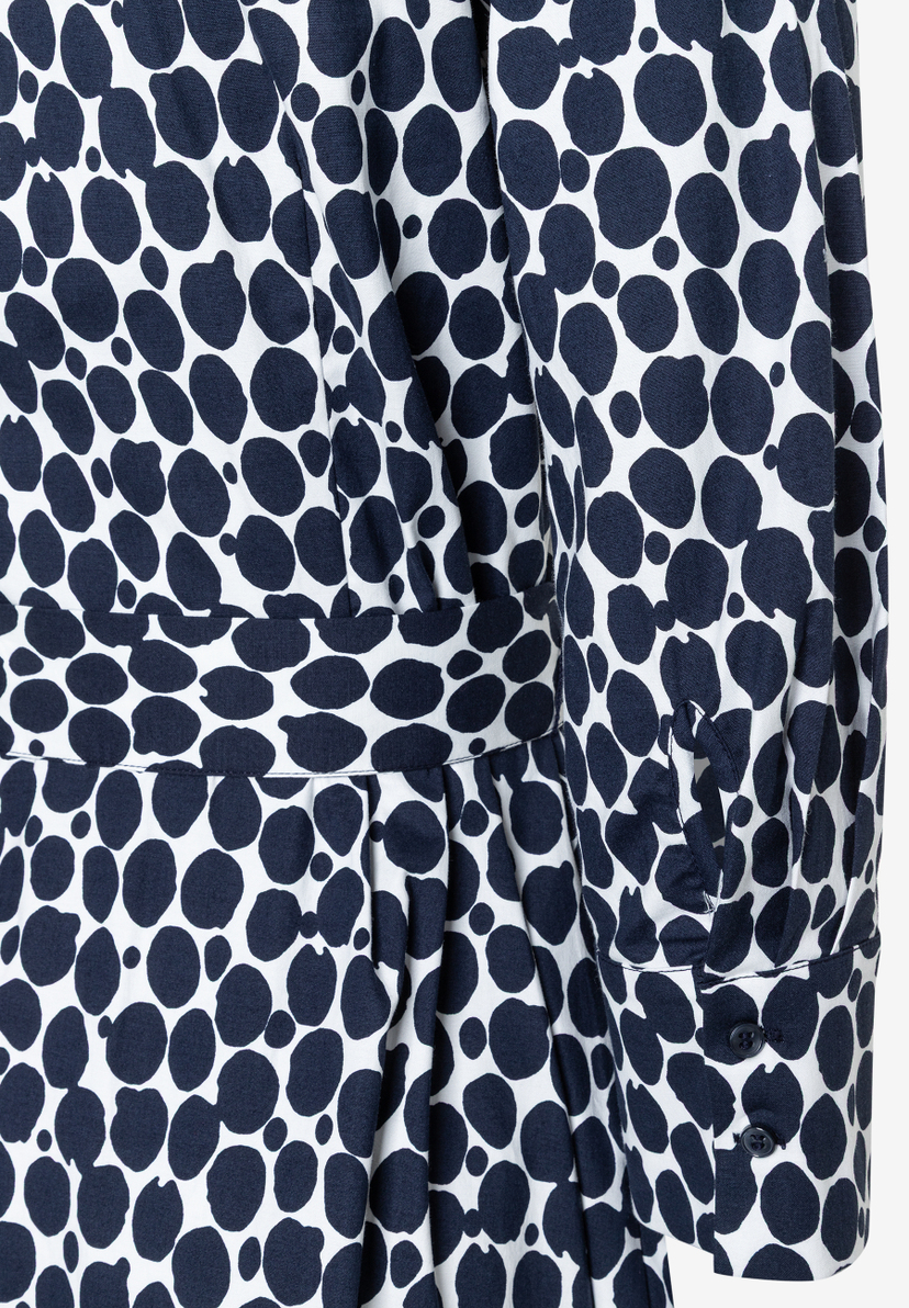 Detailaufnahme eines MORE & MORE Kleides mit blau-weißem Punktmuster und langen Ärmeln. Detailaufnahme eines MORE & MORE Kleides mit blau-weißem Punktmuster und langen Ärmeln.