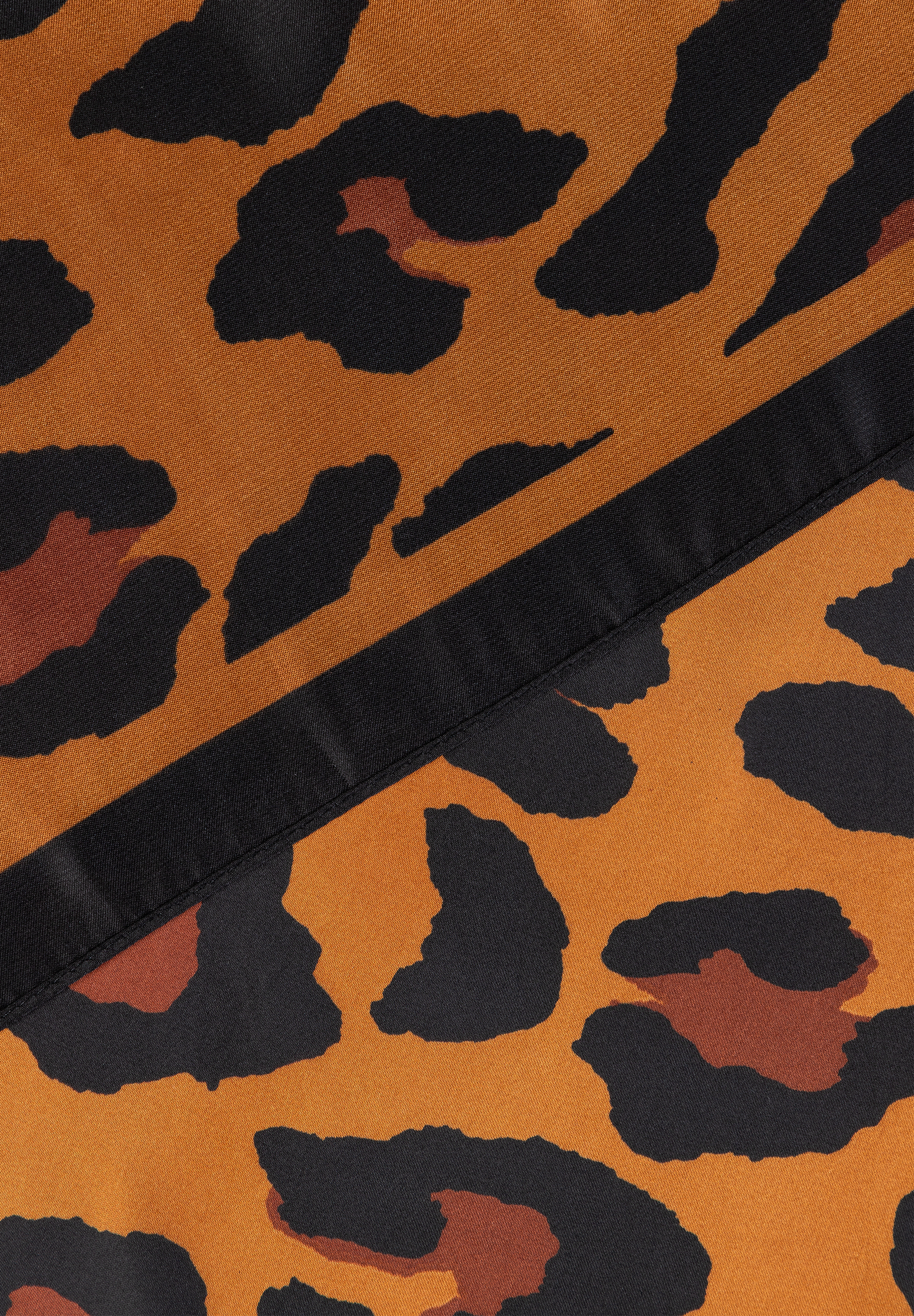 MORE & MORE Accessoires: Nahaufnahme des Stoffes mit schwarzem Leopardenmuster auf braunem Grund und einem schwarzen Streifen.
