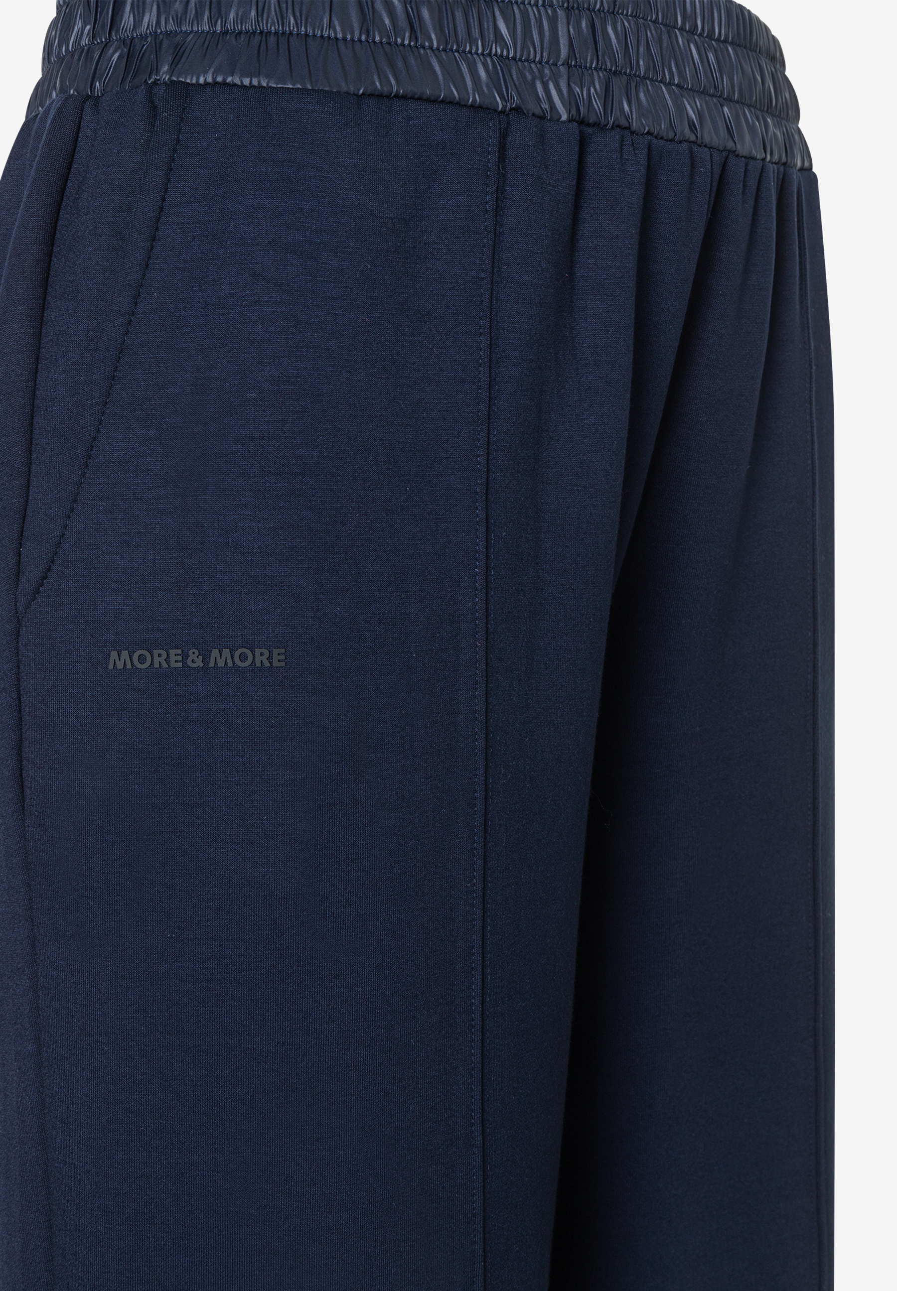 Nahaufnahme einer dunkelblauen MORE & MORE Hose mit glänzendem Bund.