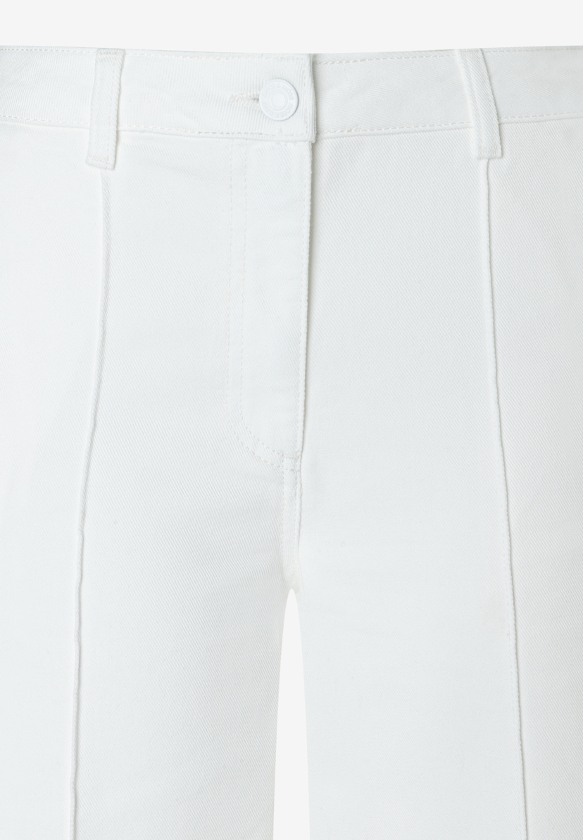 Detailaufnahme einer weißen MORE & MORE Hose/Jeans aus Twill-Webware mit Knopf und Reißverschluss. Detailaufnahme einer weißen MORE & MORE Hose/Jeans aus Twill-Webware mit Knopf und Reißverschluss.