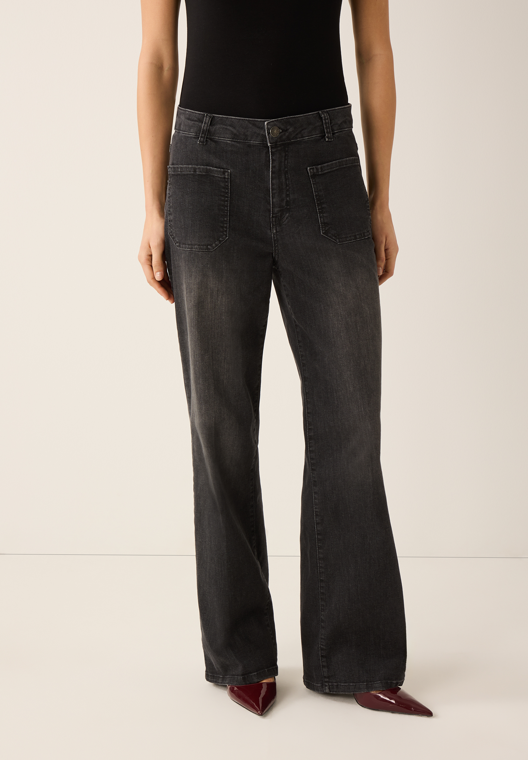 Eine elastische, dunkle Denim-Jeans von MORE & MORE mit ausgestelltem Bein und aufgesetzten Taschen.