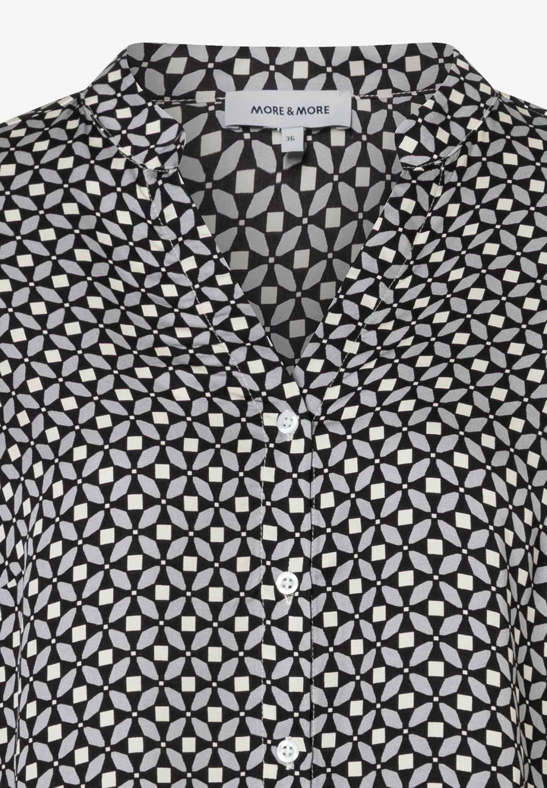 Nahaufnahme einer MORE & MORE Bluse mit geometrischem Muster und Knopfleiste. Nahaufnahme einer MORE & MORE Bluse mit geometrischem Muster und Knopfleiste.