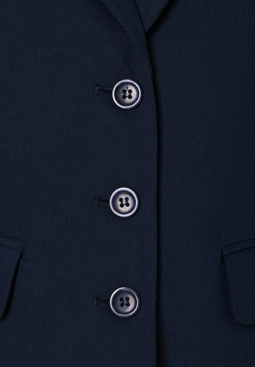 Nahaufnahme eines blauen MORE & MORE Blazers mit drei Knöpfen und Webware-Material. Nahaufnahme eines blauen MORE & MORE Blazers mit drei Knöpfen und Webware-Material.