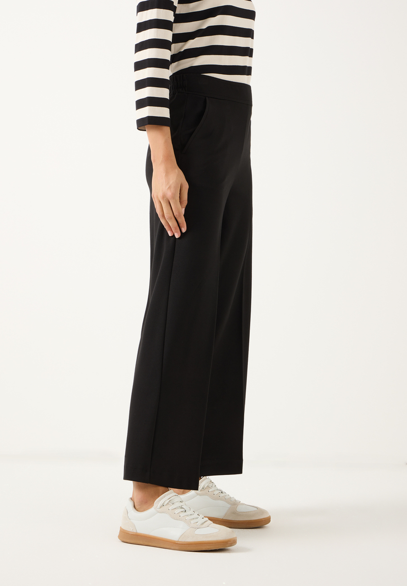 MORE & MORE Damen Jersey-Jeans: Eine Nahaufnahme einer Frau, die eine schwarze, elastische Jersey-Hose trägt. MORE & MORE Damen Jersey-Jeans: Eine Nahaufnahme einer Frau, die eine schwarze, elastische Jersey-Hose trägt.