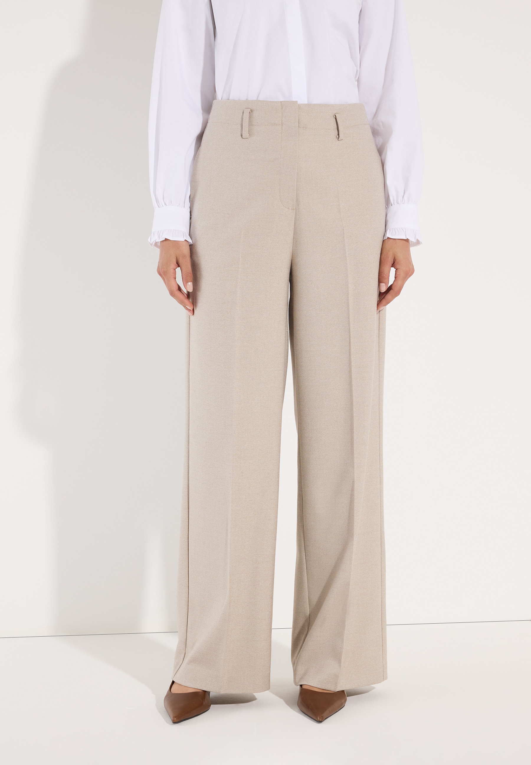 MORE & MORE Viskosemischung Jeans: Eine junge Frau trägt eine cremefarbene Weste mit Kapuze und eine weiße Bluse.