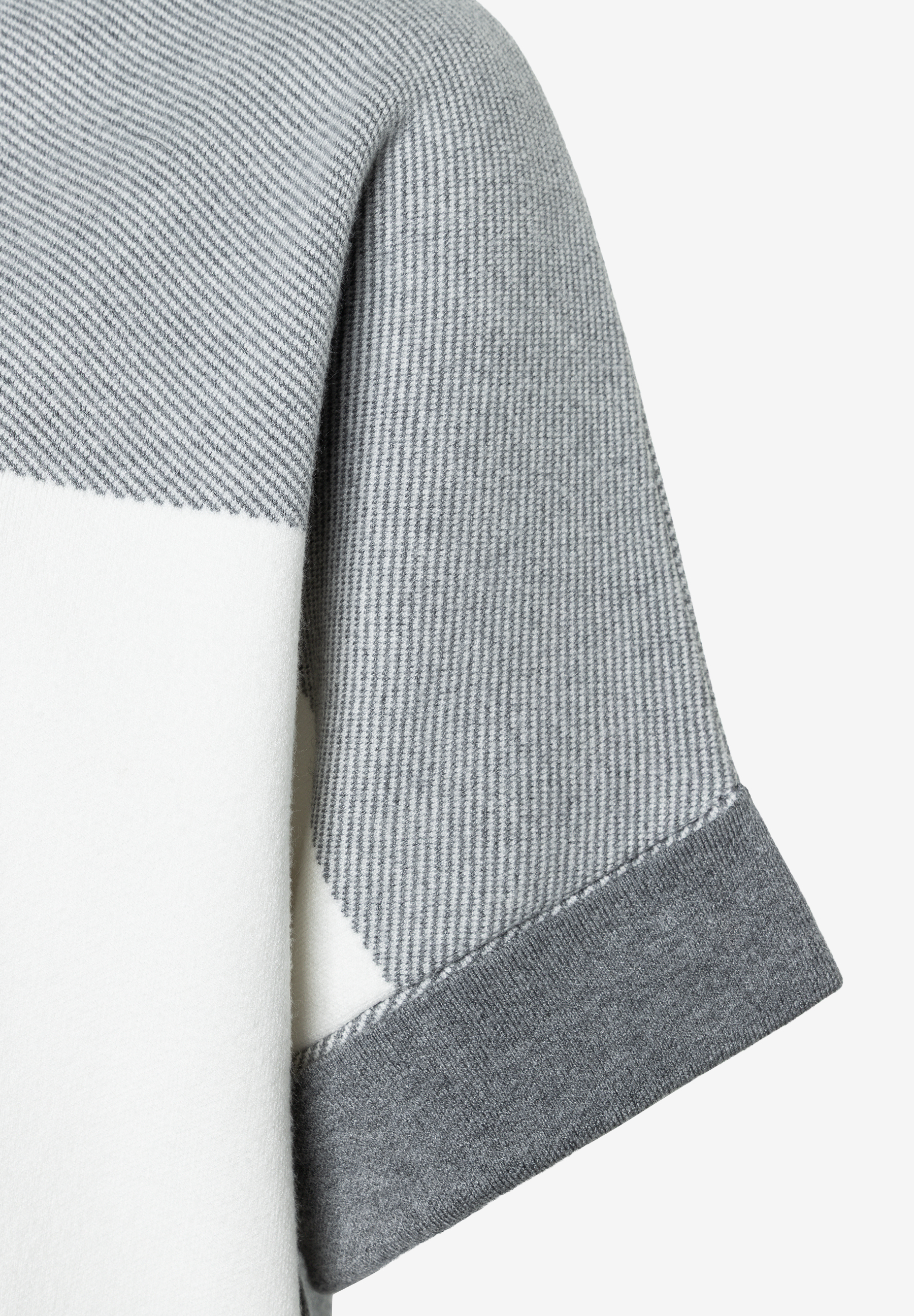 MORE & MORE Oberteil: Nahaufnahme des grauen Strickpullovers mit diagonalen und vertikalen Streifen und weissen Blöcken. MORE & MORE Oberteil: Nahaufnahme des grauen Strickpullovers mit diagonalen und vertikalen Streifen und weissen Blöcken.