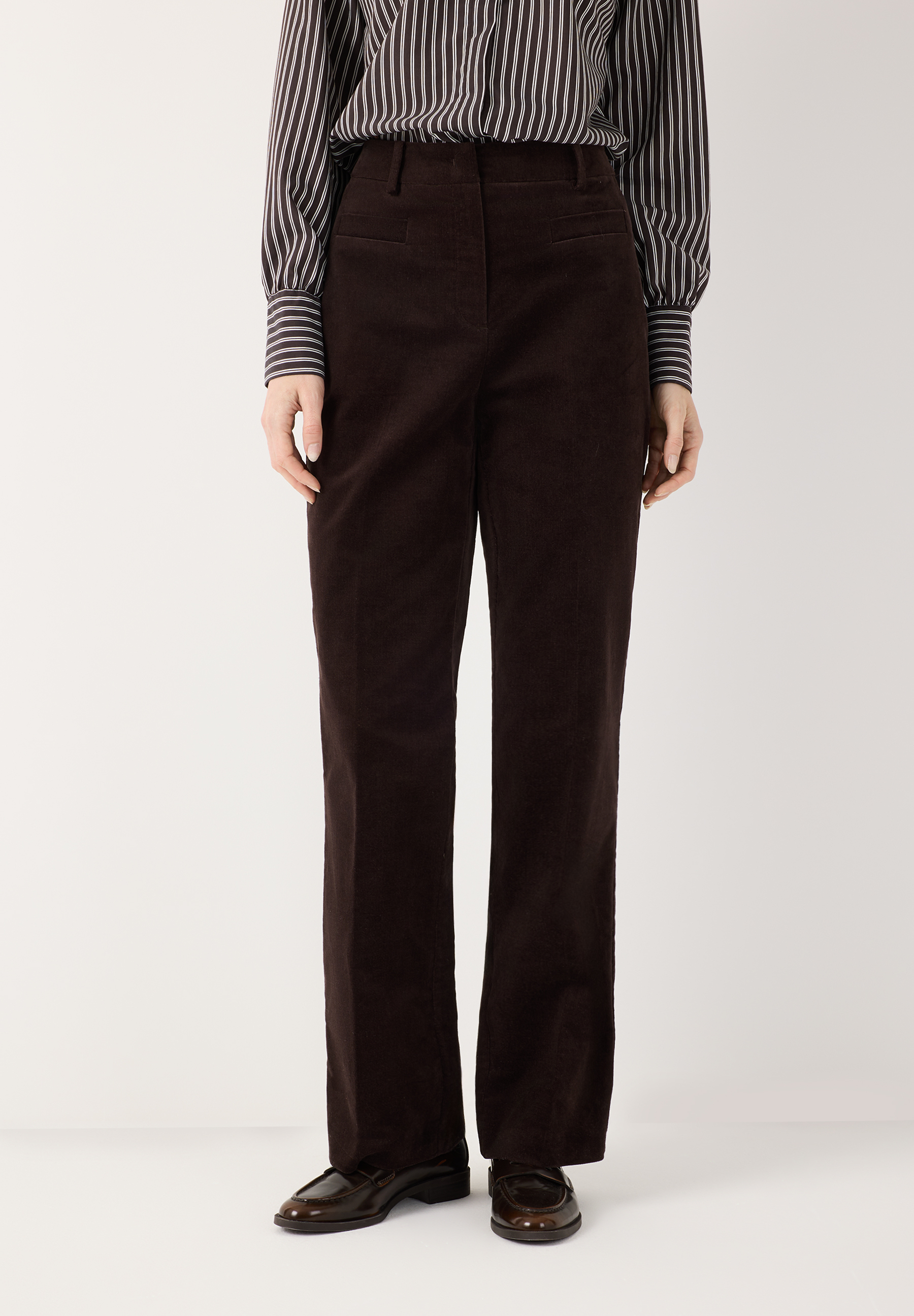 MORE & MORE Cord-Hose in Dunkelbraun, dazu ein gestreiftes Hemd und braune Loafer.