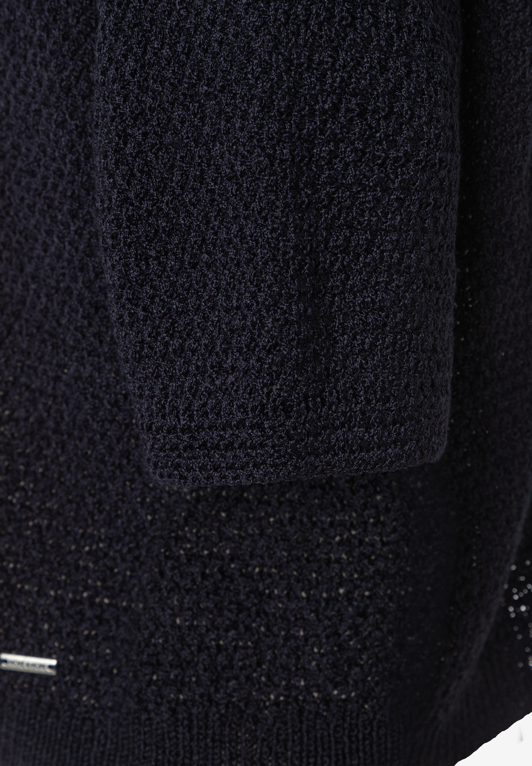 Nahaufnahme eines dunkelblauen MORE & MORE Strickpullovers, der eine feine Textur und ein dezentes Markenlogo zeigt. Nahaufnahme eines dunkelblauen MORE & MORE Strickpullovers, der eine feine Textur und ein dezentes Markenlogo zeigt.