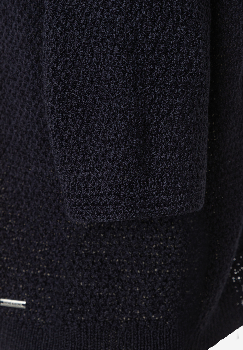 Nahaufnahme eines dunkelblauen MORE & MORE Strickpullovers, der eine feine Textur und ein dezentes Markenlogo zeigt. Nahaufnahme eines dunkelblauen MORE & MORE Strickpullovers, der eine feine Textur und ein dezentes Markenlogo zeigt.