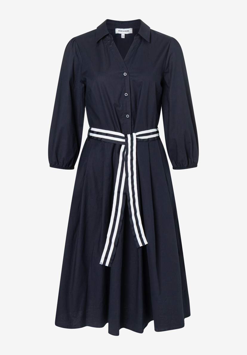 Ein blaues MORE & MORE Hemdblusenkleid mit weiß gestreiftem Gürtel auf hellem Hintergrund. Ein blaues MORE & MORE Hemdblusenkleid mit weiß gestreiftem Gürtel auf hellem Hintergrund.