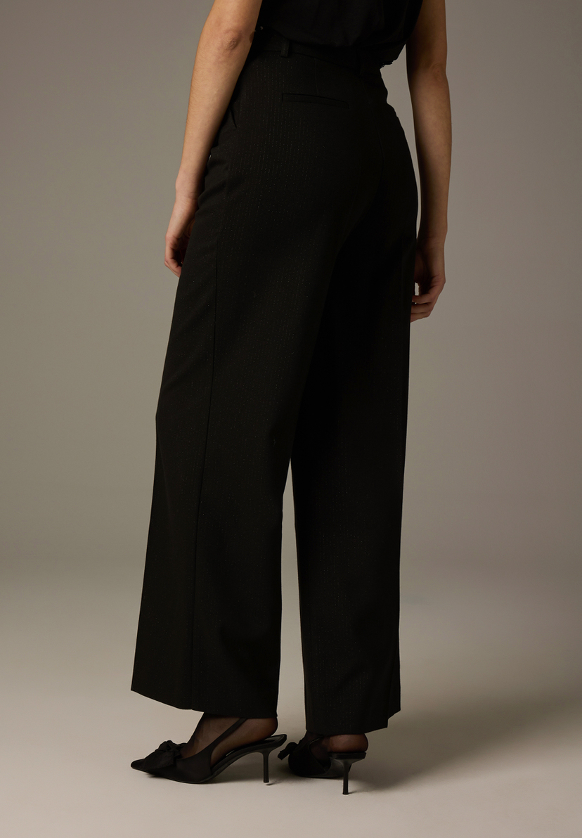 Eine Person von hinten, trägt MORE & MORE Hose/Jeans aus Webware mit bequemem, elastischem Tragekomfort und Schuhe mit Absatz. Eine Person von hinten, trägt MORE & MORE Hose/Jeans aus Webware mit bequemem, elastischem Tragekomfort und Schuhe mit Absatz.