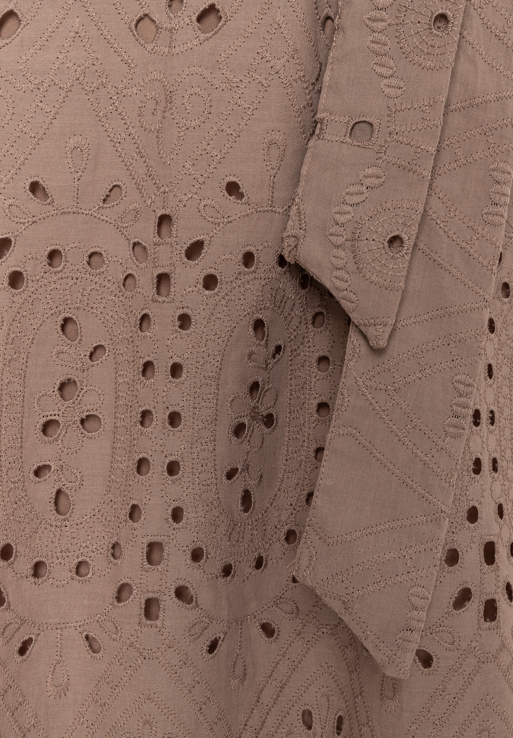 Nahaufnahme eines MORE & MORE Oberteils mit Spitze und Lochstickerei in Braun.