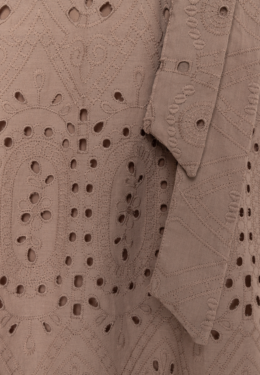 Nahaufnahme eines MORE & MORE Oberteils mit Spitze und Lochstickerei in Braun.