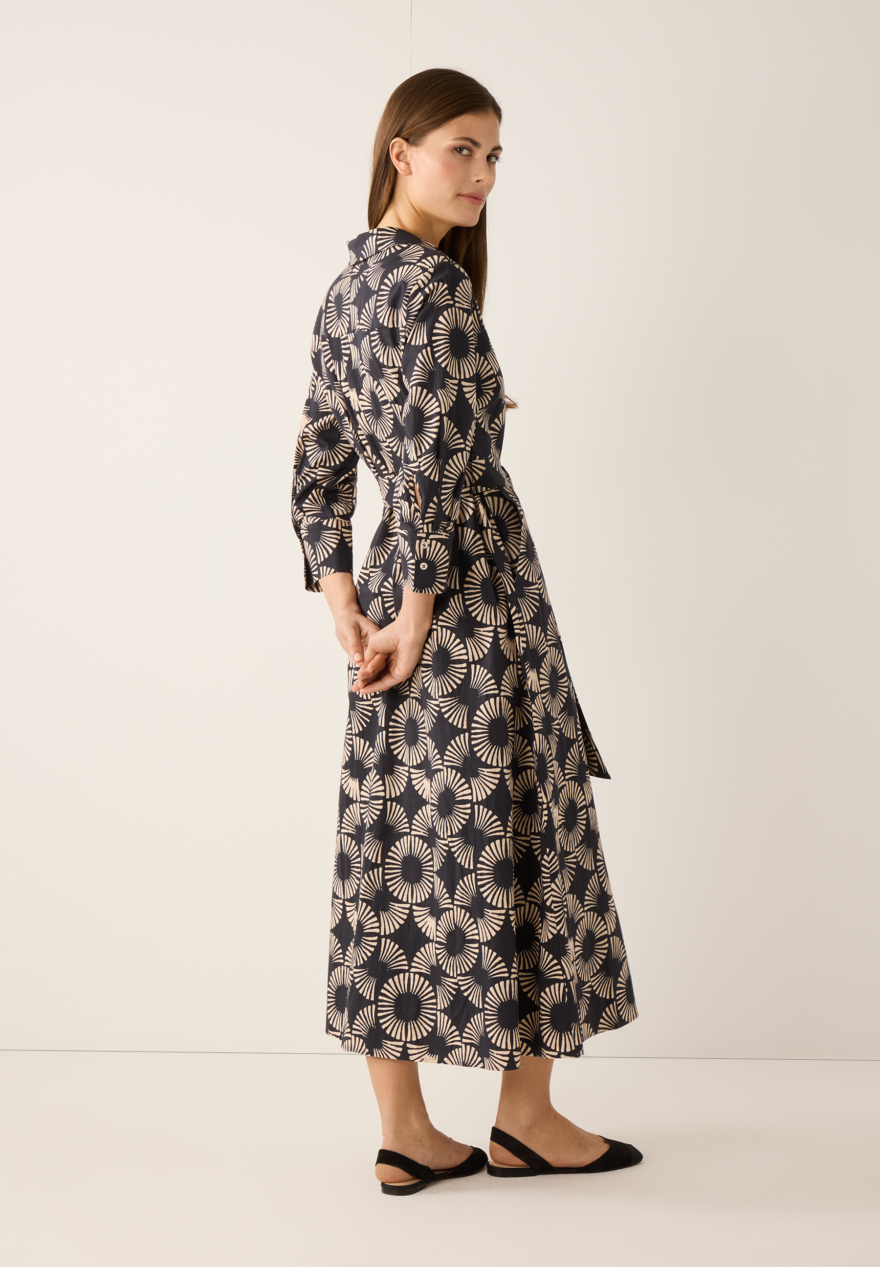 Eine Frau in einem MORE & MORE Popeline-Kleid mit Stretch und Musterung von hinten. Eine Frau in einem MORE & MORE Popeline-Kleid mit Stretch und Musterung von hinten.