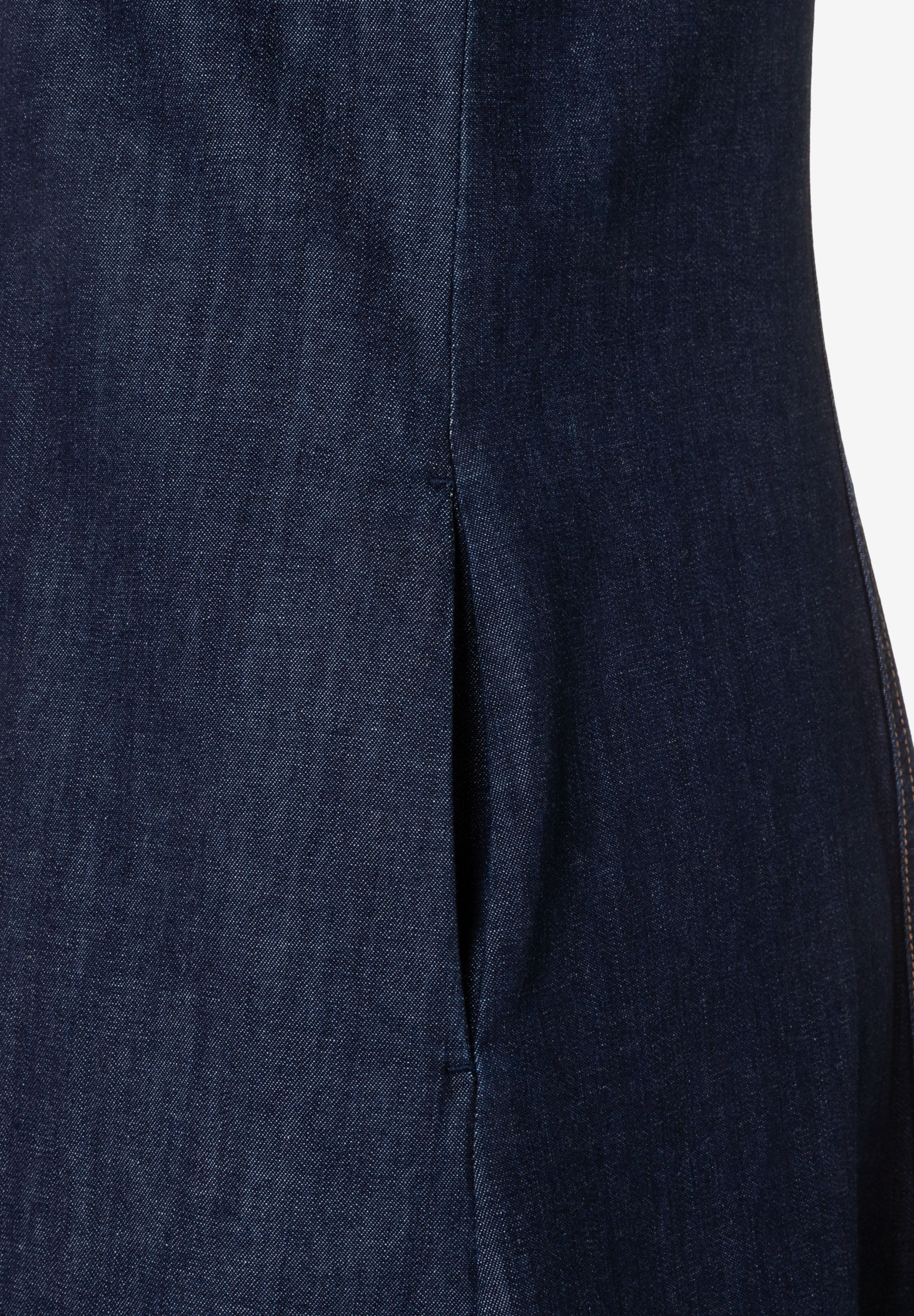 Nahaufnahme eines MORE & MORE Oberteils aus blauem Denim mit Schlitz. Nahaufnahme eines MORE & MORE Oberteils aus blauem Denim mit Schlitz.