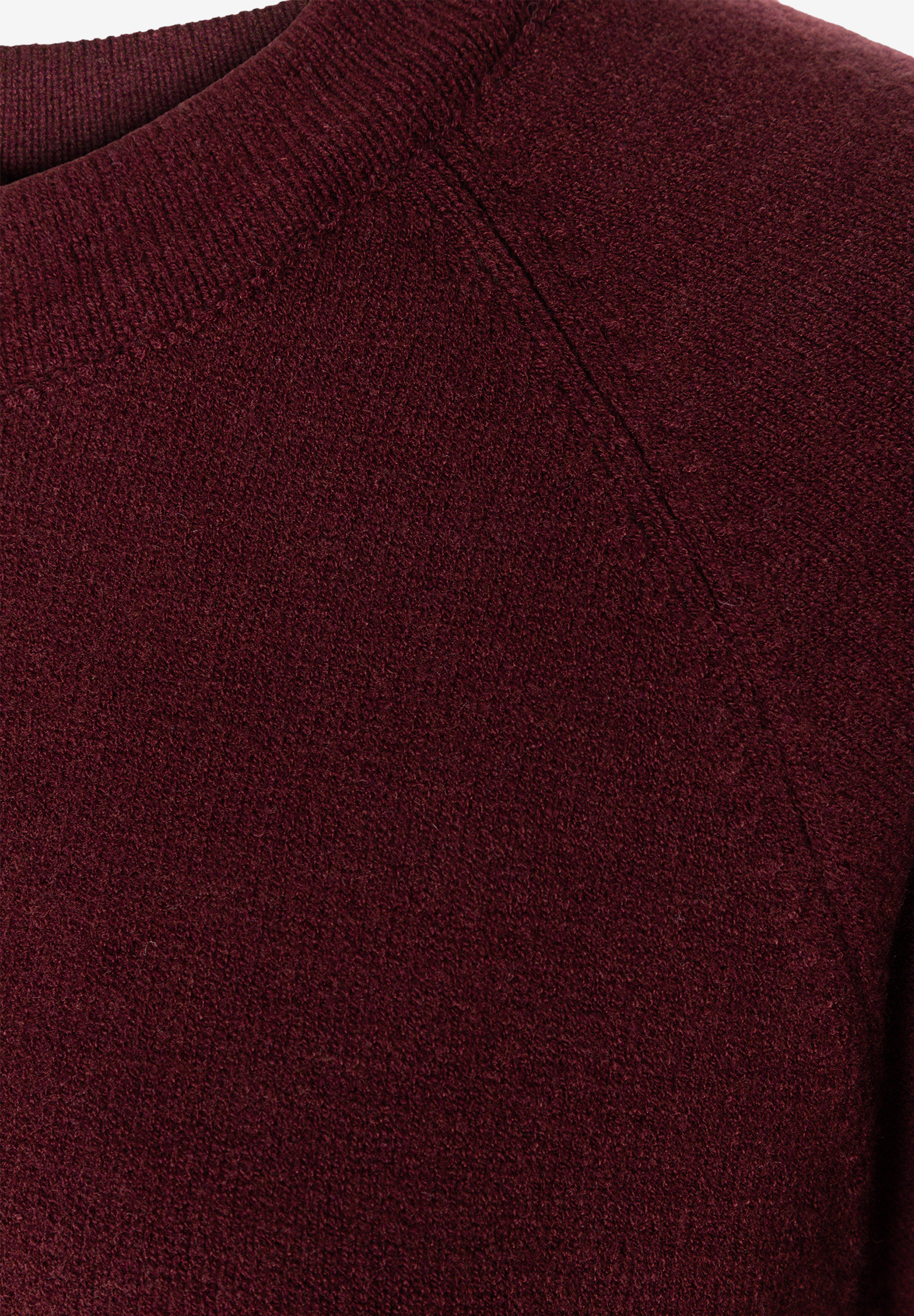 MORE & MORE Pullover: Detailaufnahme eines weinroten Strickpullovers mit Raglanärmelnaht und geripptem Rundhalsausschnitt.