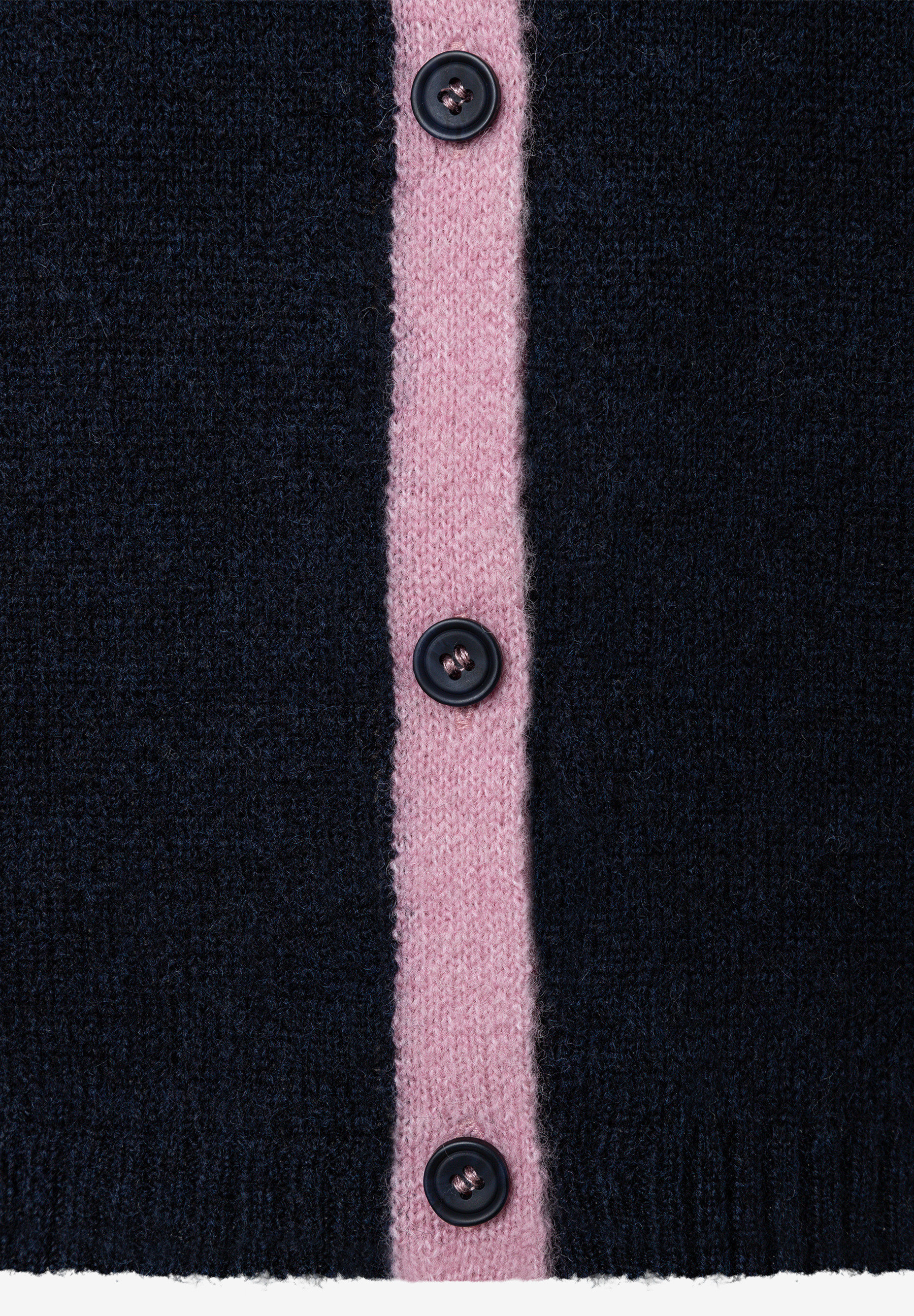 MORE & MORE Pullover & Strickwaren: Nahaufnahme einer dunkelblauen Strickjacke mit einem rosa Streifen in der Mitte und drei dunklen Knöpfen. MORE & MORE Pullover & Strickwaren: Nahaufnahme einer dunkelblauen Strickjacke mit einem rosa Streifen in der Mitte und drei dunklen Knöpfen.