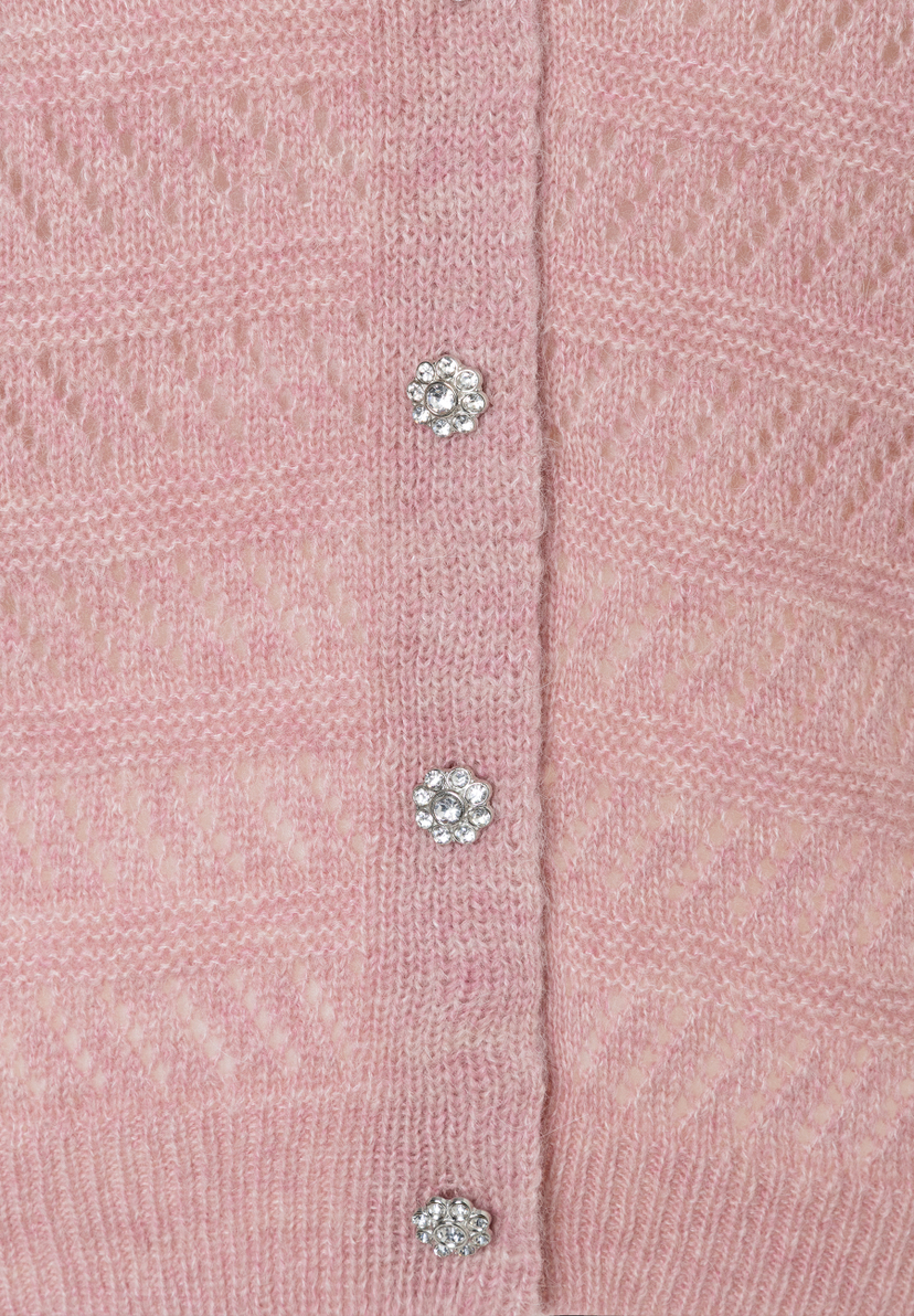 Nahaufnahme eines rosa MORE & MORE Oberteils mit Lochstrick und glitzernden Zierknöpfen. Nahaufnahme eines rosa MORE & MORE Oberteils mit Lochstrick und glitzernden Zierknöpfen.